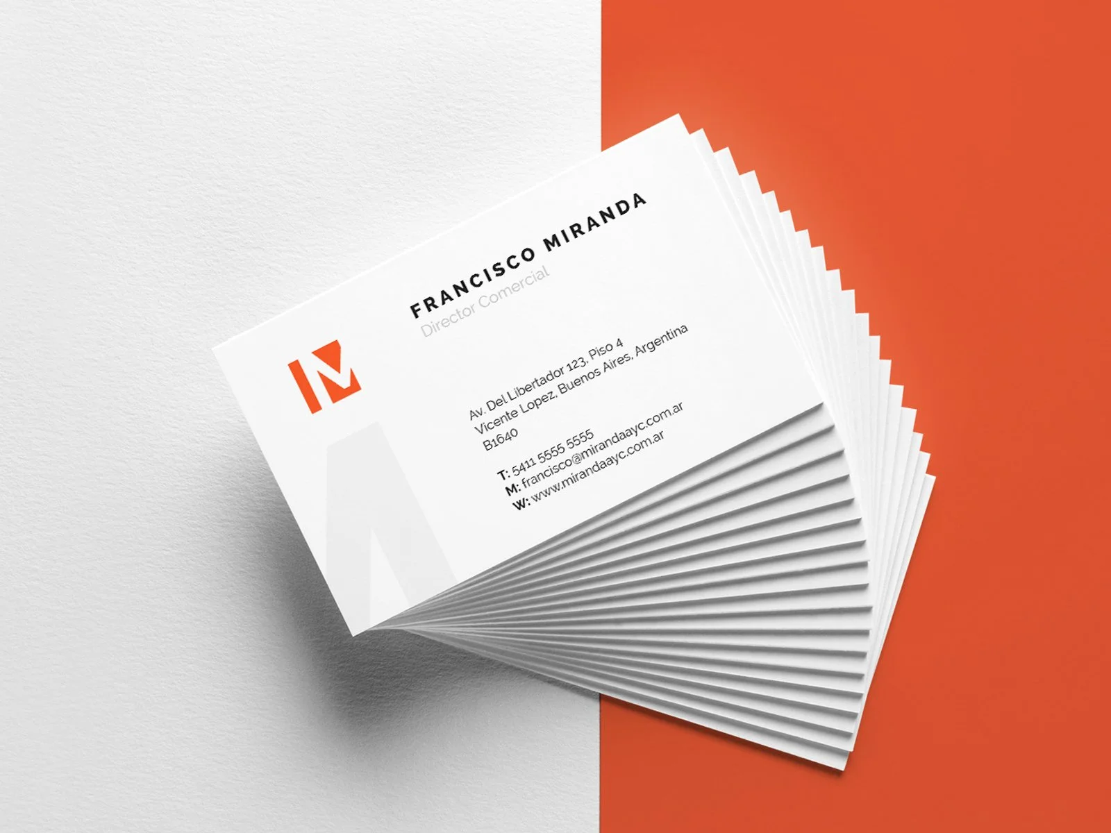 Tarjetas de presentación apiladas sobre una superficie dividida en blanco y naranja, mostrando un nombre, cargo, dirección, teléfono, email y sitio web.