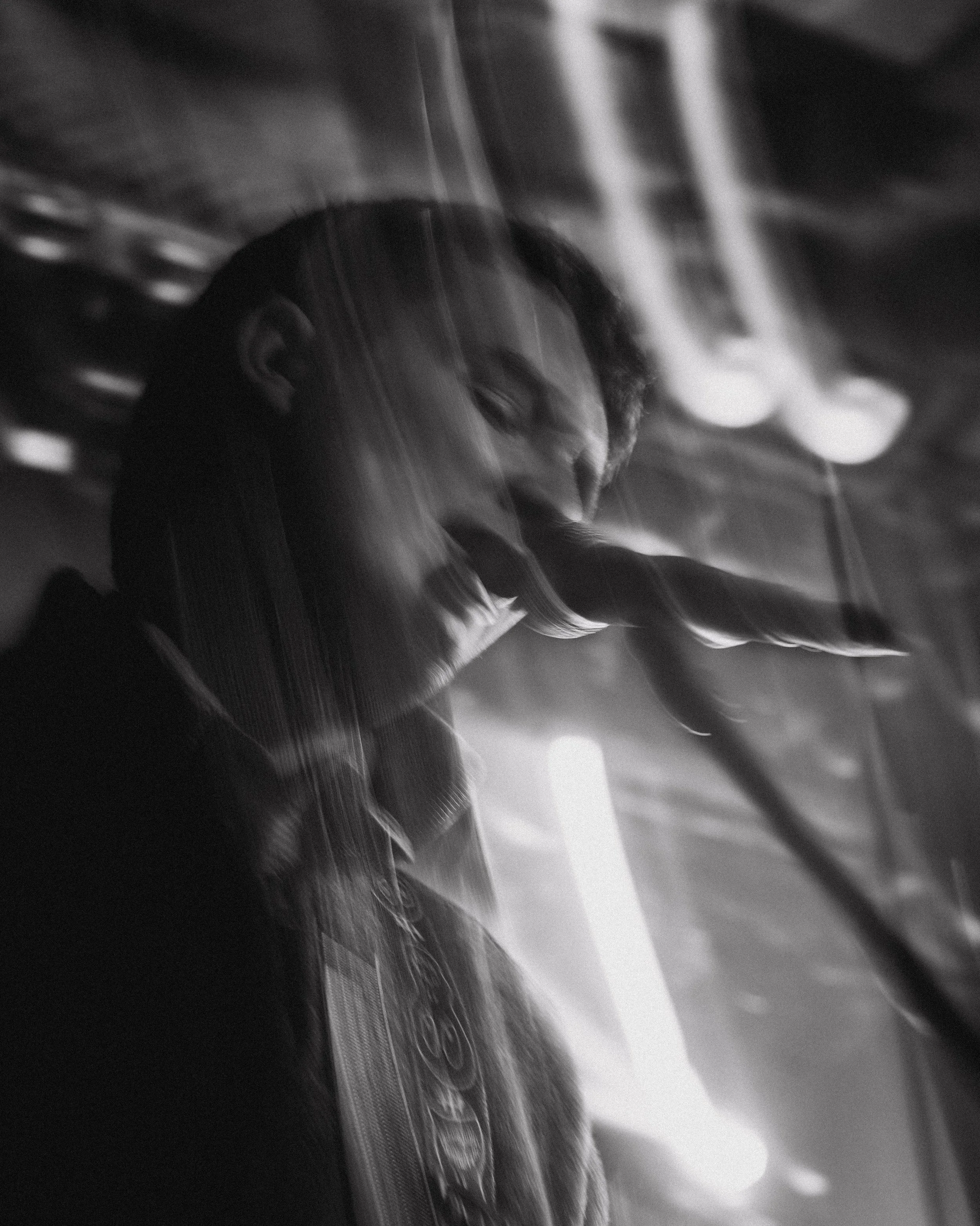 A black and white photo of a person singing into a microphone.