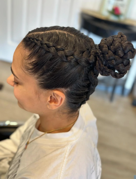 Side view of a woman with an intricate updo hairstyle featuring braided hair and a large bun.