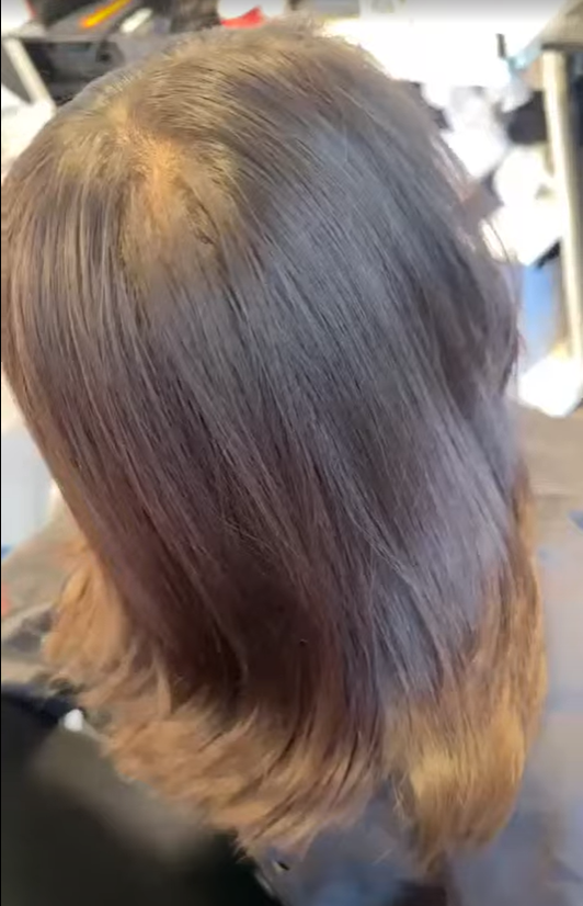 Top view of a person's head with freshly trimmed brown hair.