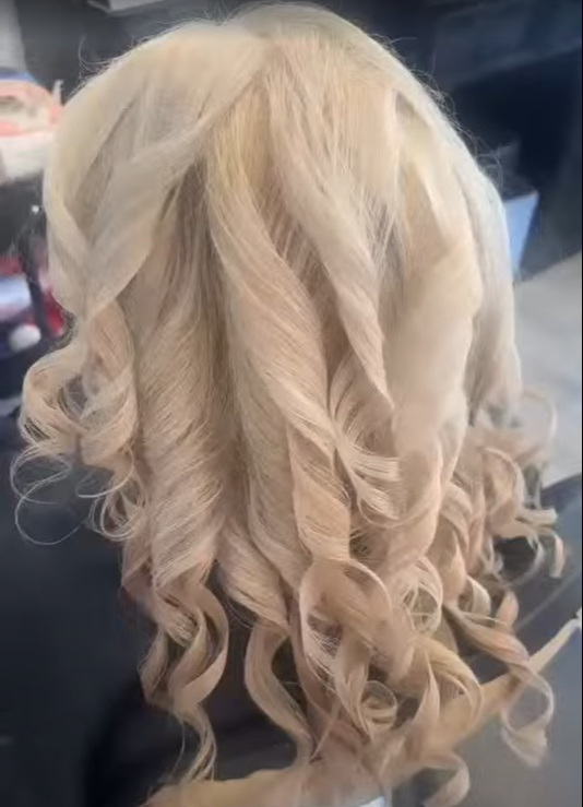 Blonde hair styled in loose, defined curls.