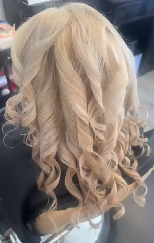 Blonde hair styled in loose curls, viewed from behind.