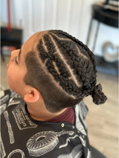 Child with cornrows and an undercut hairstyle in a salon.
