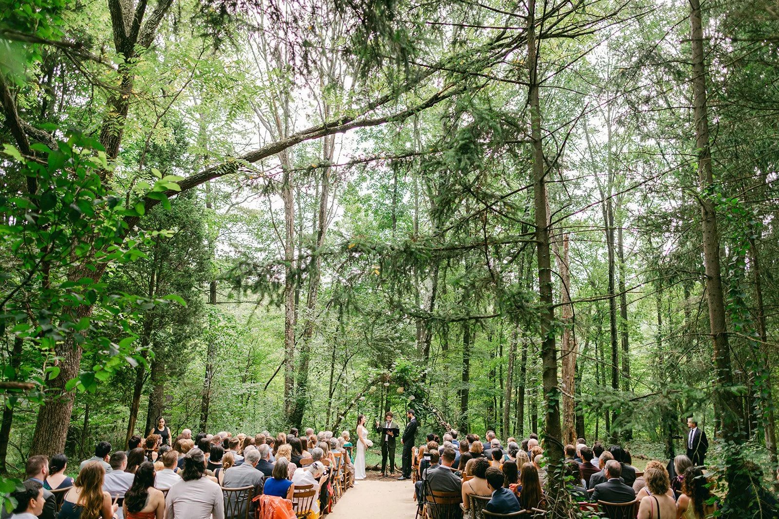A bride and groom say vows in a majestic forest at Black Walnut Farm in upstate New York
