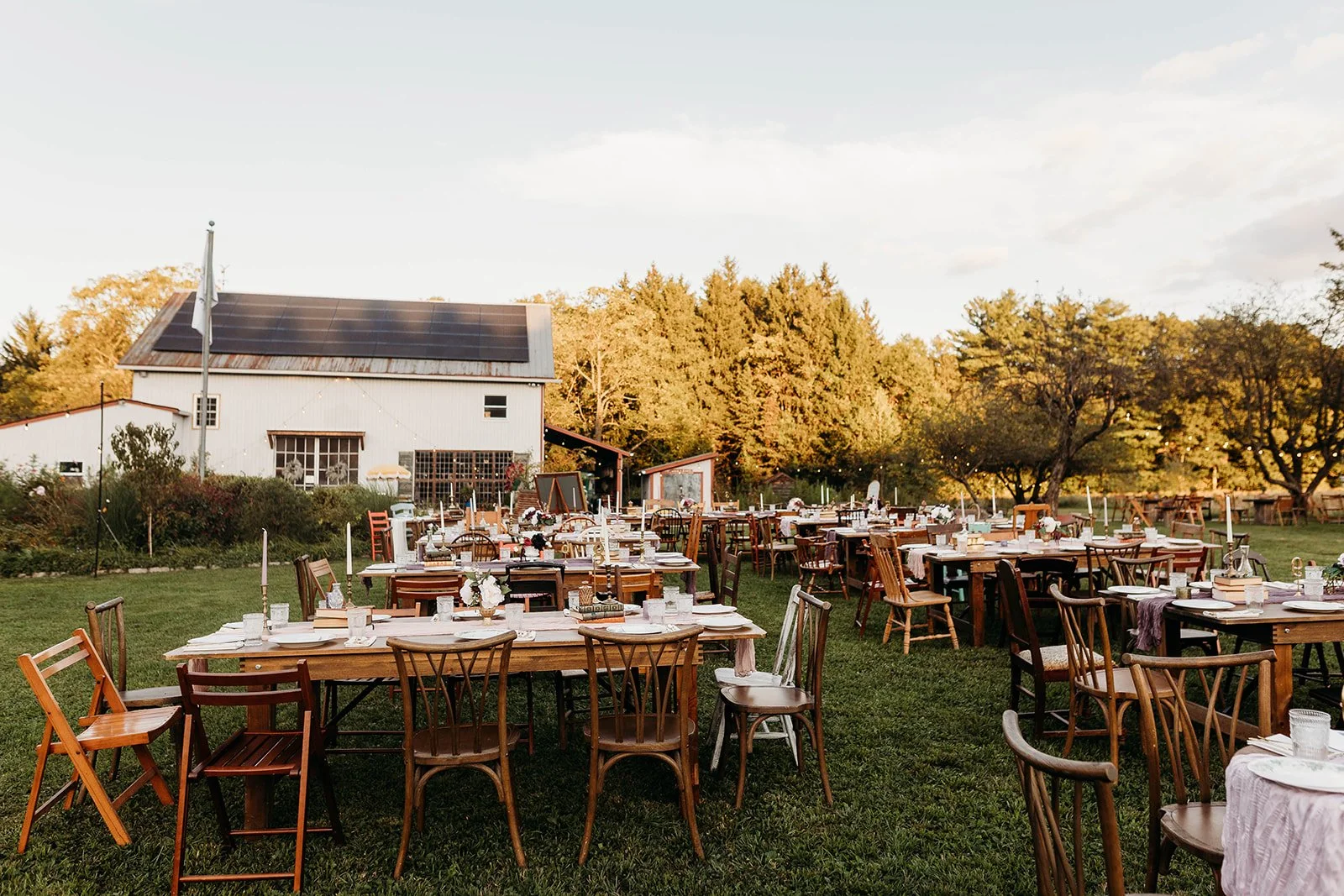 Rustic farm tables in front of a country barn at sunset