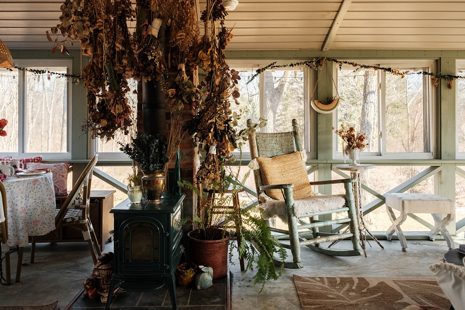 a sun-filled porch space with wicker furniture and dried flowers black walnut farm
