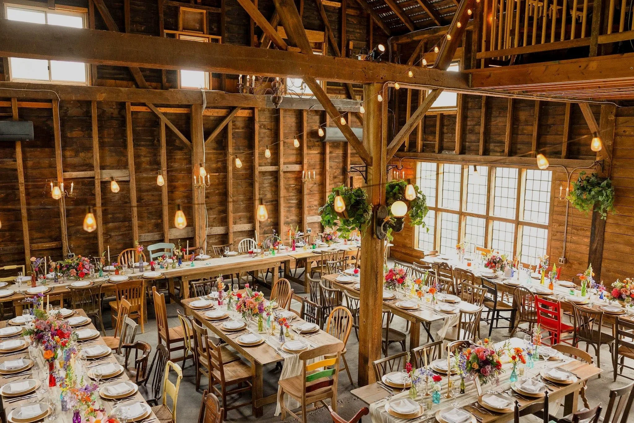Rustic farm tables and chairs and a beautiful dinner setup at wedding venue Black Walnut Farm