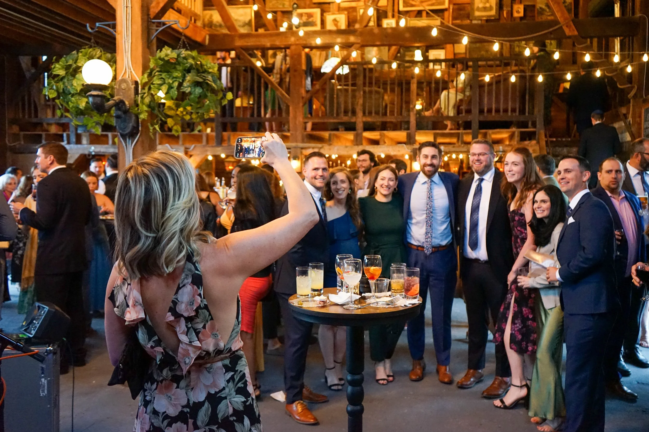 A group poses for a photo during a cocktail hour in the barn.
