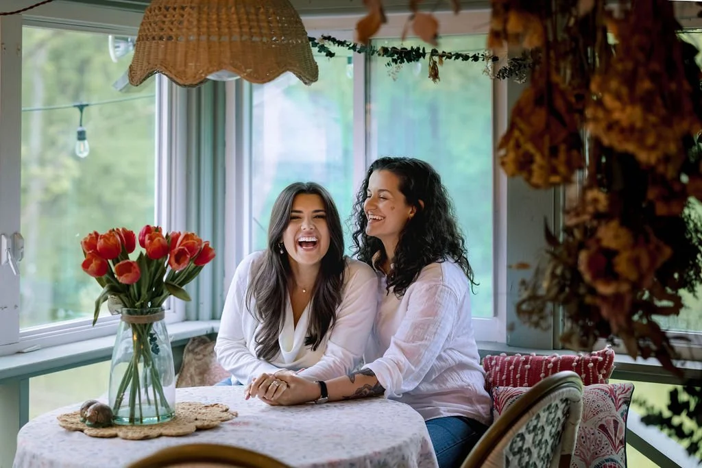 two women relax at a table in a charming screen porch at Black Walnut Farm