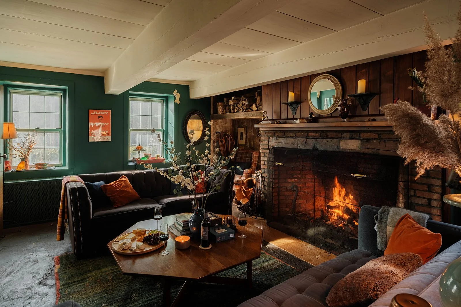 A cozy fire and jewel toned velvet sofas with a cheese board and wine.