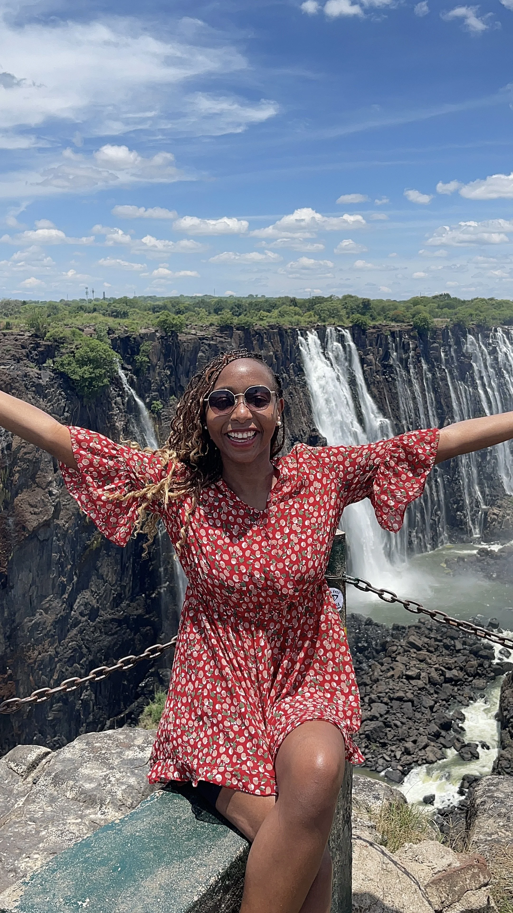 Patience M. Chigodora sitting on the waterbanks of the victoria falls, zimbabwe