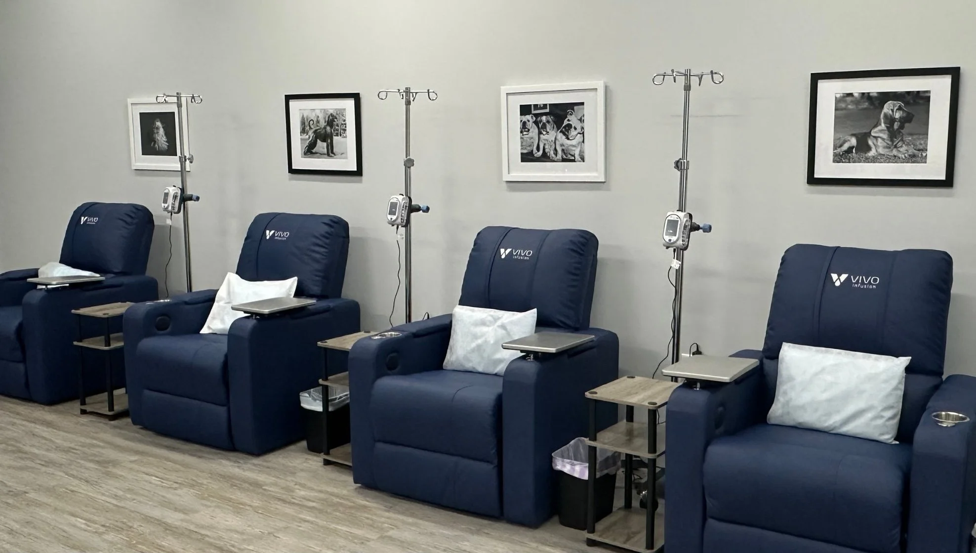four blue recliner chairs with medical equipment next to them