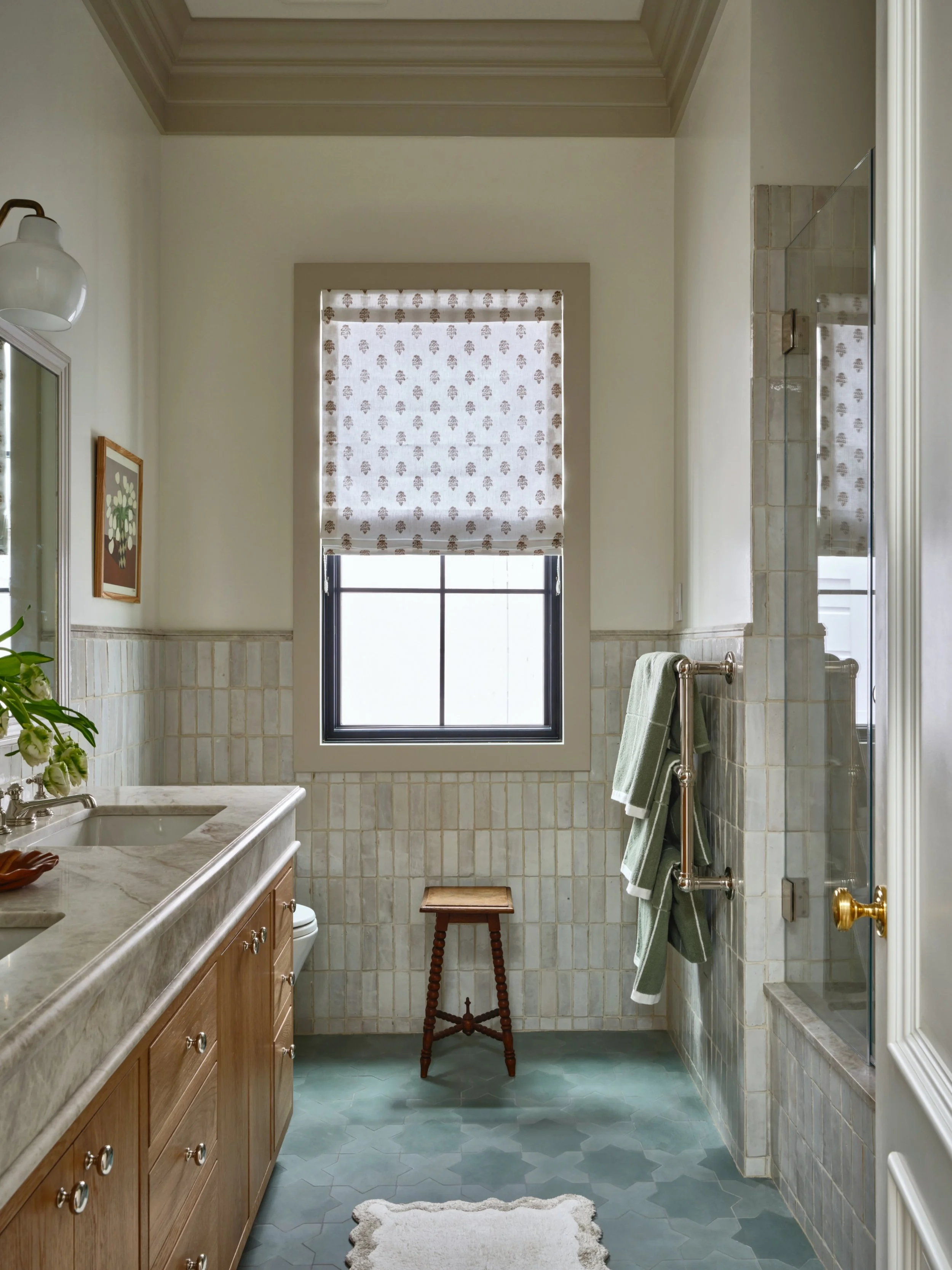 Shared kids bathroom in San Francisco with very tall ceilings. Often with small rooms and very high ceilings you get a strange elevator shaft effect. One solve is to drop the ceiling, but in this case we solved for that with a tiled wainscoting, whic