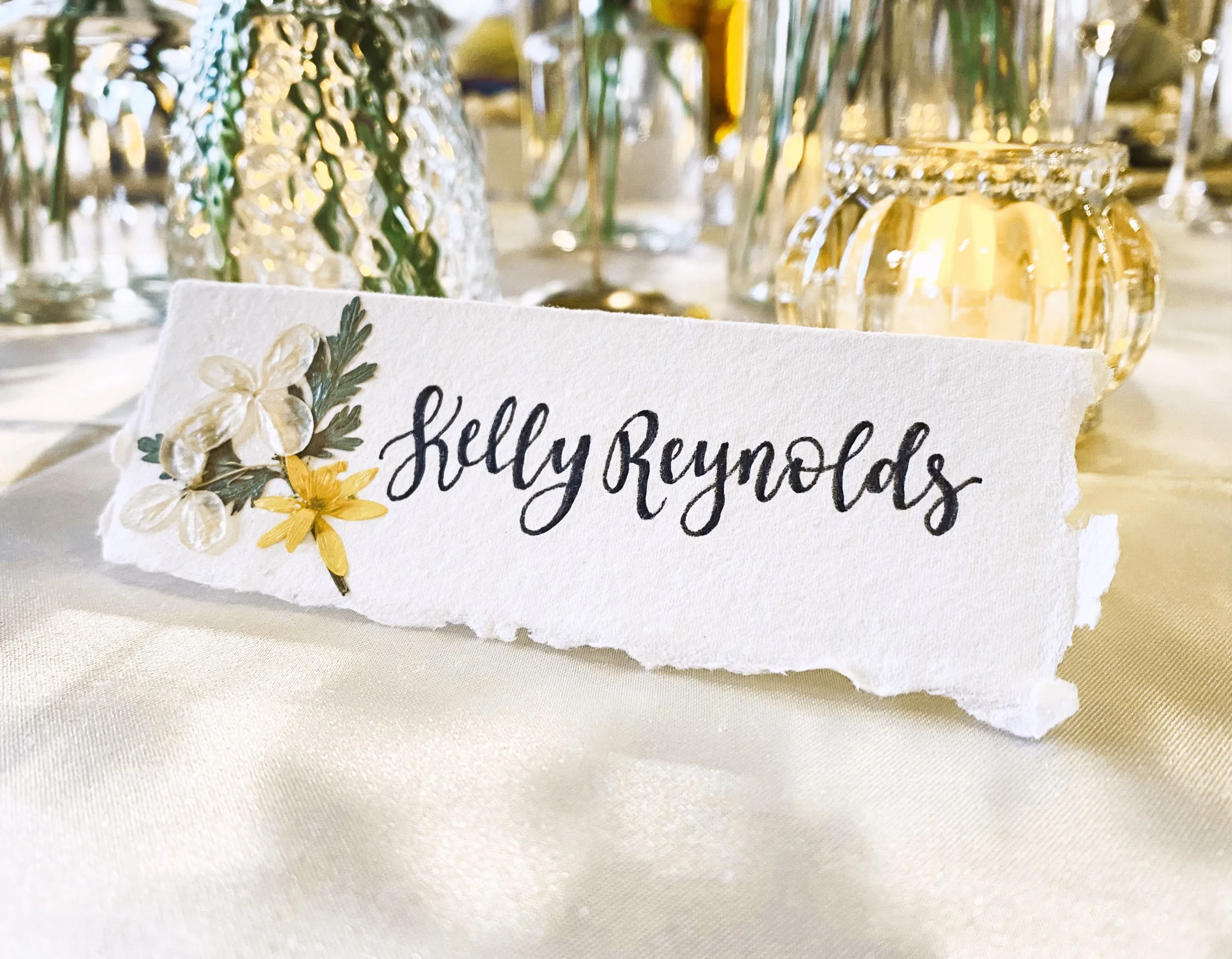 Wedding table name card with pressed flowers and hand lettered calligraphy
