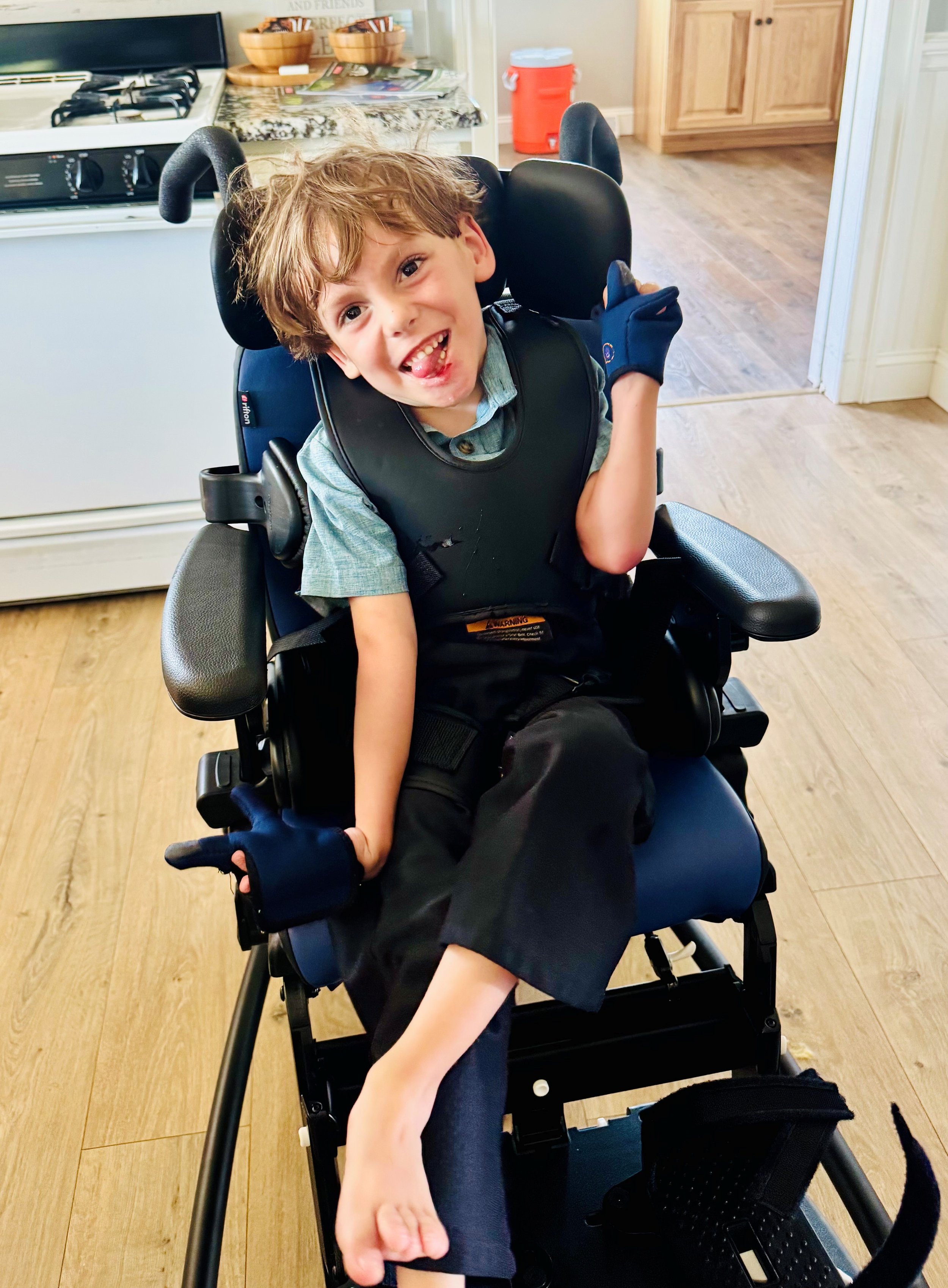 Elmer smiling in his new blue activity chair