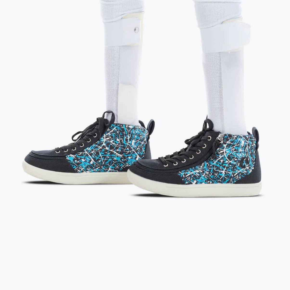 BILLY adaptive kids D|R High Top Sneaker shown in a black with a blue graffiti print running up the inner and outer middle shown on a model wearing AFO braces