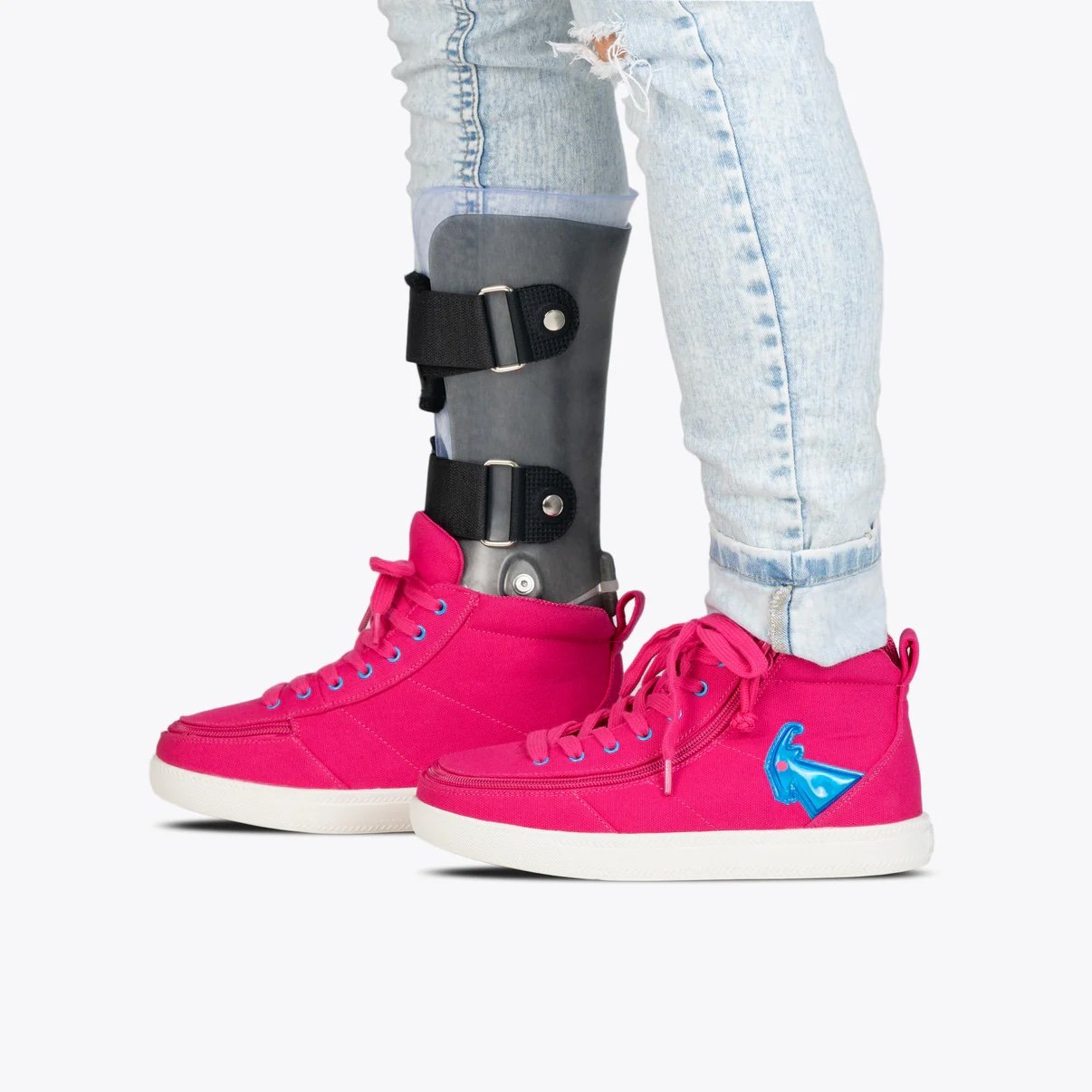 BILLY kids light up high top adaptive sneakers in bright pink shown on a model wearing an AFO brace and light wash jeans