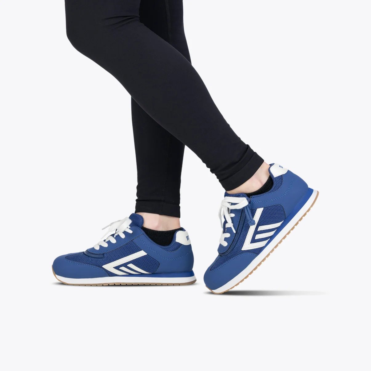 BILLY kids adaptive retro jogger sneaker in royal blue with white logo shown on a model with black leggings