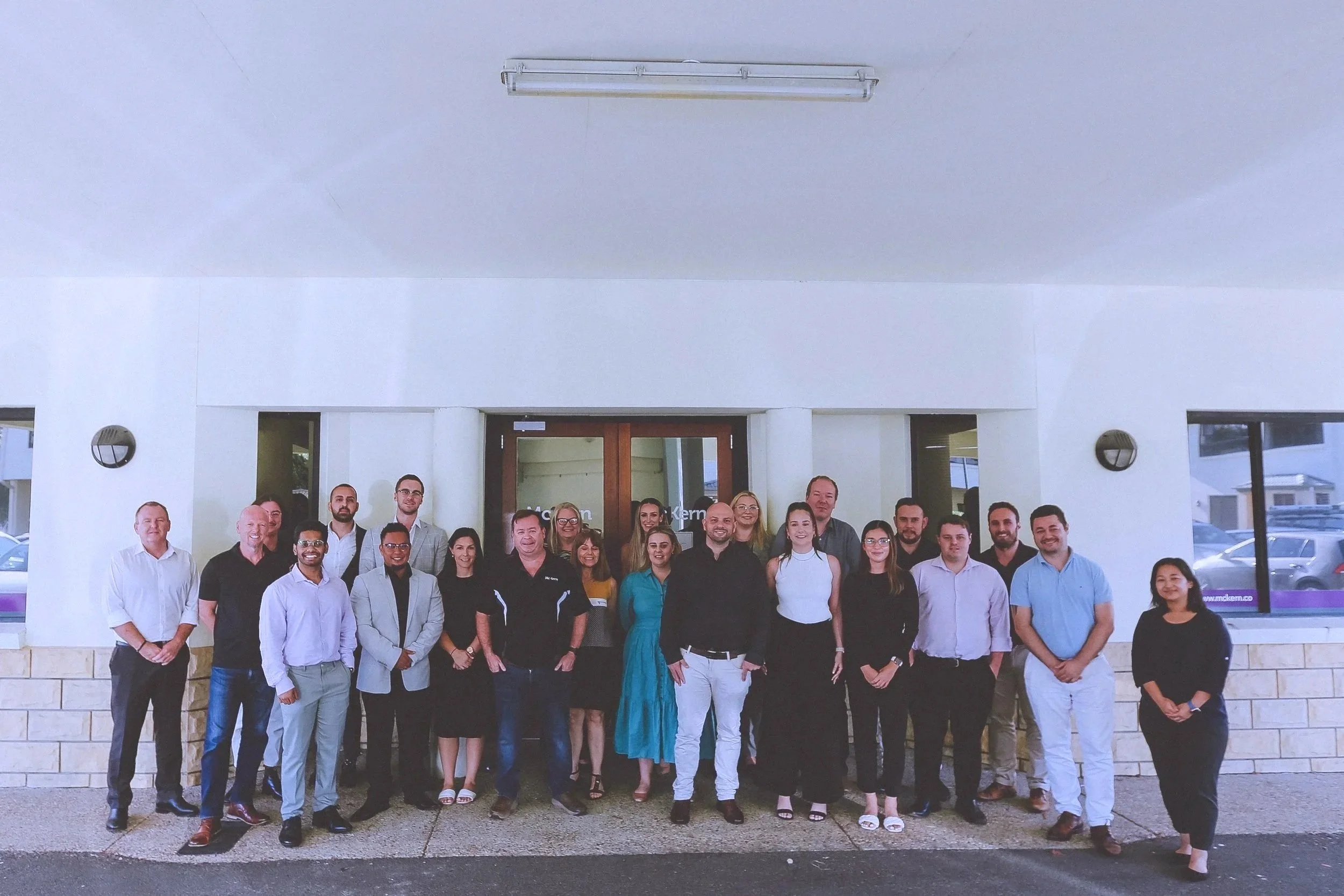 a group of people who work at mckern standing in front of the mckern door.