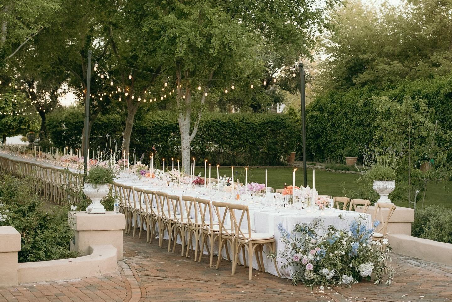 Having one long dinner table at a wedding creates a unique and intimate atmosphere. Unlike separate tables, it encourages guests to interact more easily, fostering conversations and connections among everyone present. It also provides a sense of unit