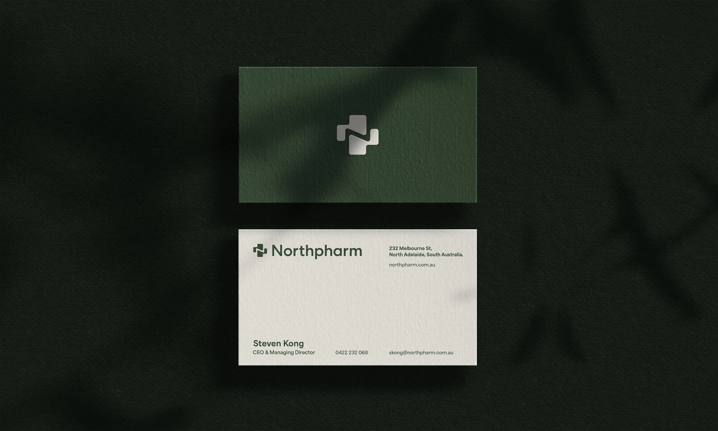 A business card and an envelope for Northpharm, placed on a dark fabric background. The card has the Northpharm logo, the company address in North Adelaide, South Australia, and contact information for Steven Kong, CEO and Managing Director.