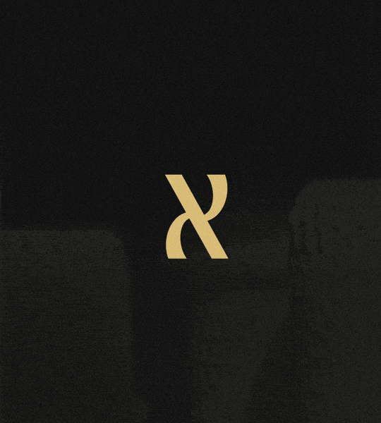 A black background with a gold stylized letter X in the center.