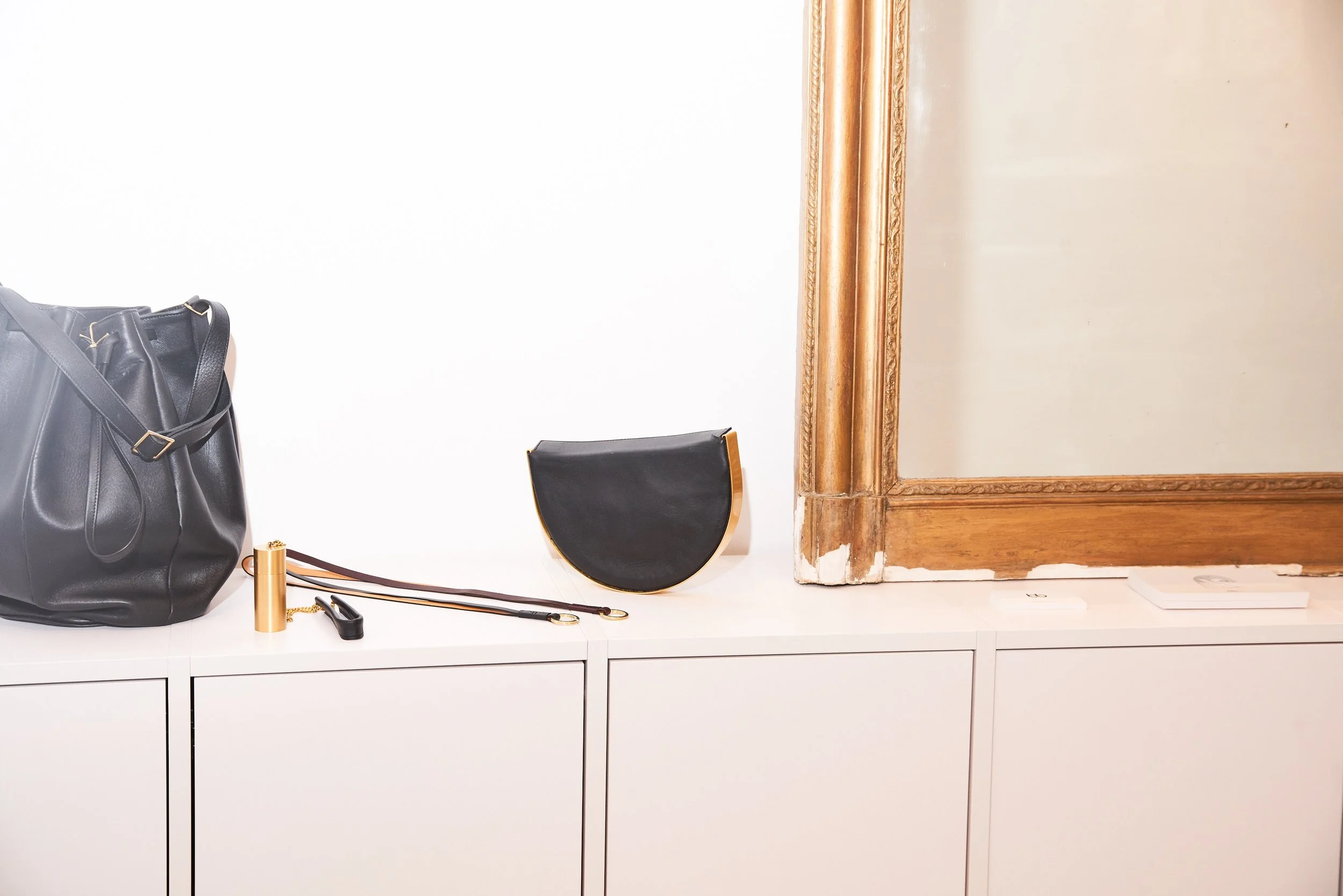 Rangements intégrés blancs et miroir ancien doré dans l'atelier-boutique de Munich, avec sacs en cuir Bea Bühler