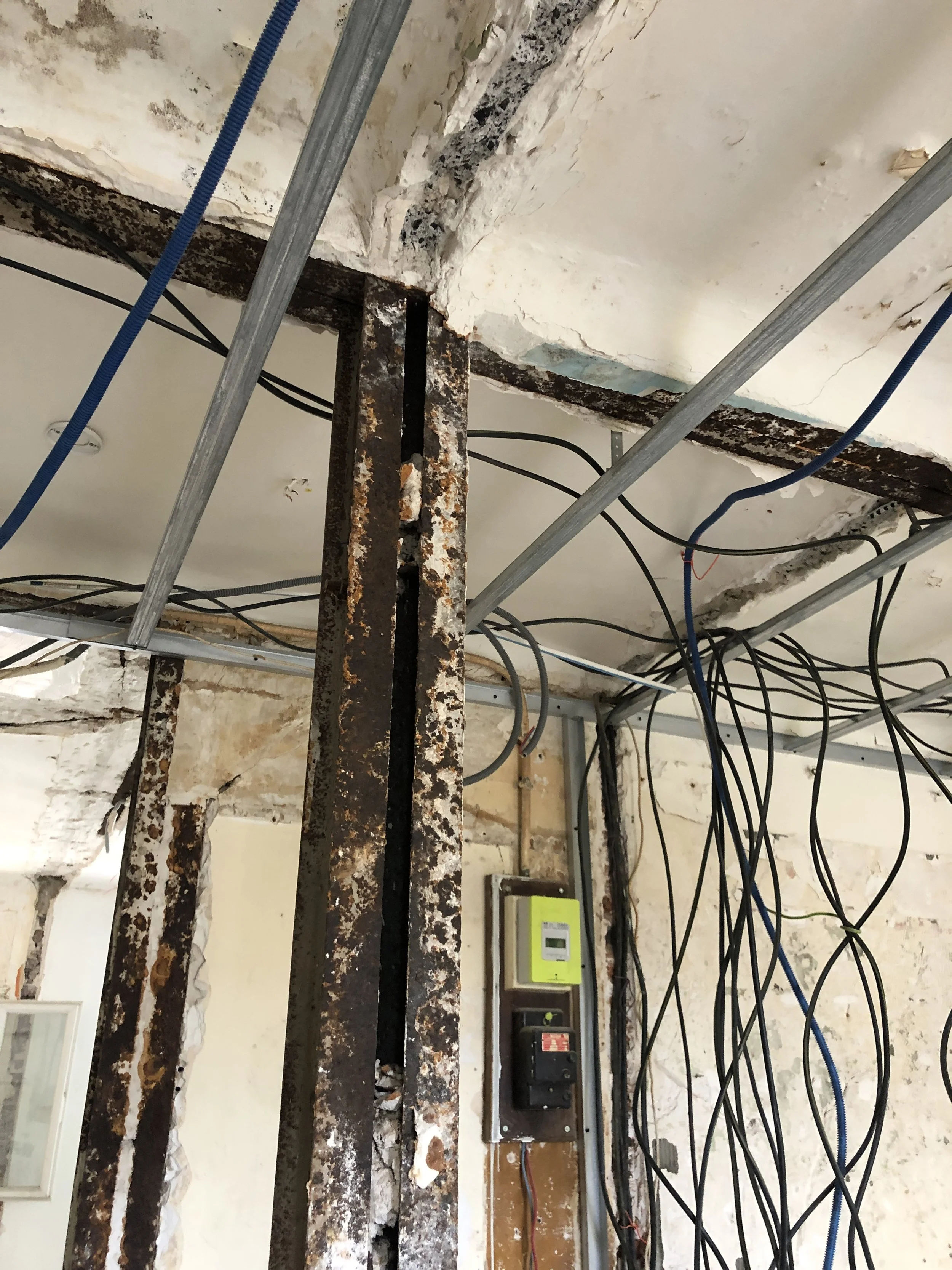 Chantier : réseaux électriques et poutres métalliques apparents au plafond avant fermeture des cloisons