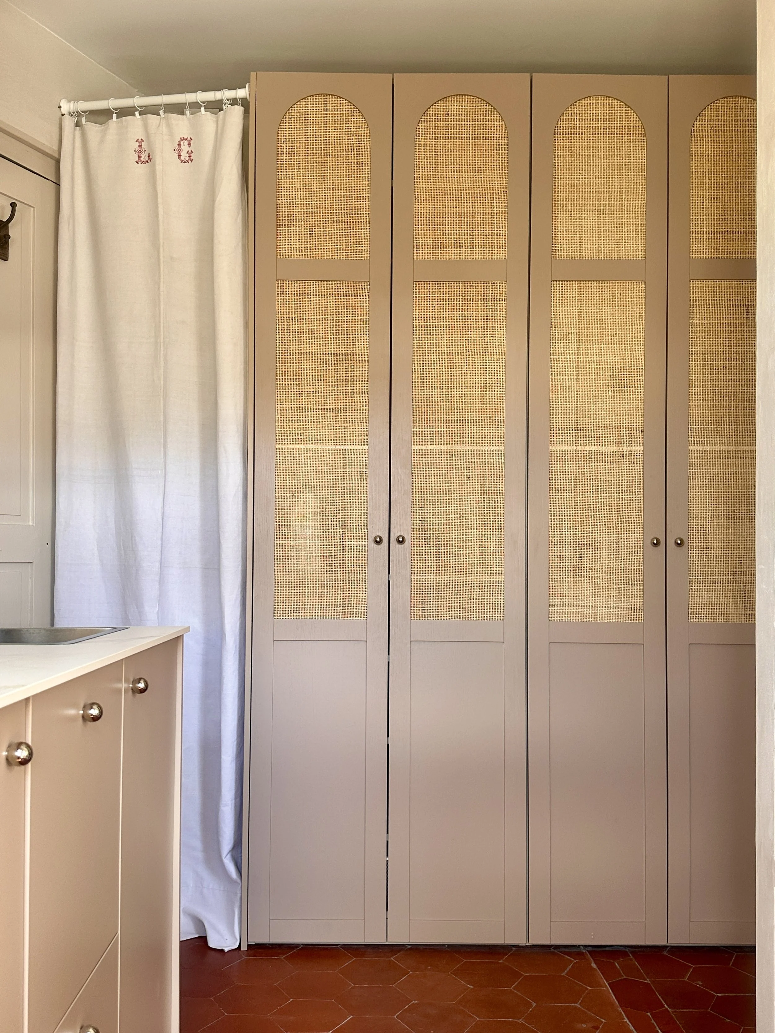 Dressing à portes cannées intégrant la buanderie, posé sur tomettes anciennes