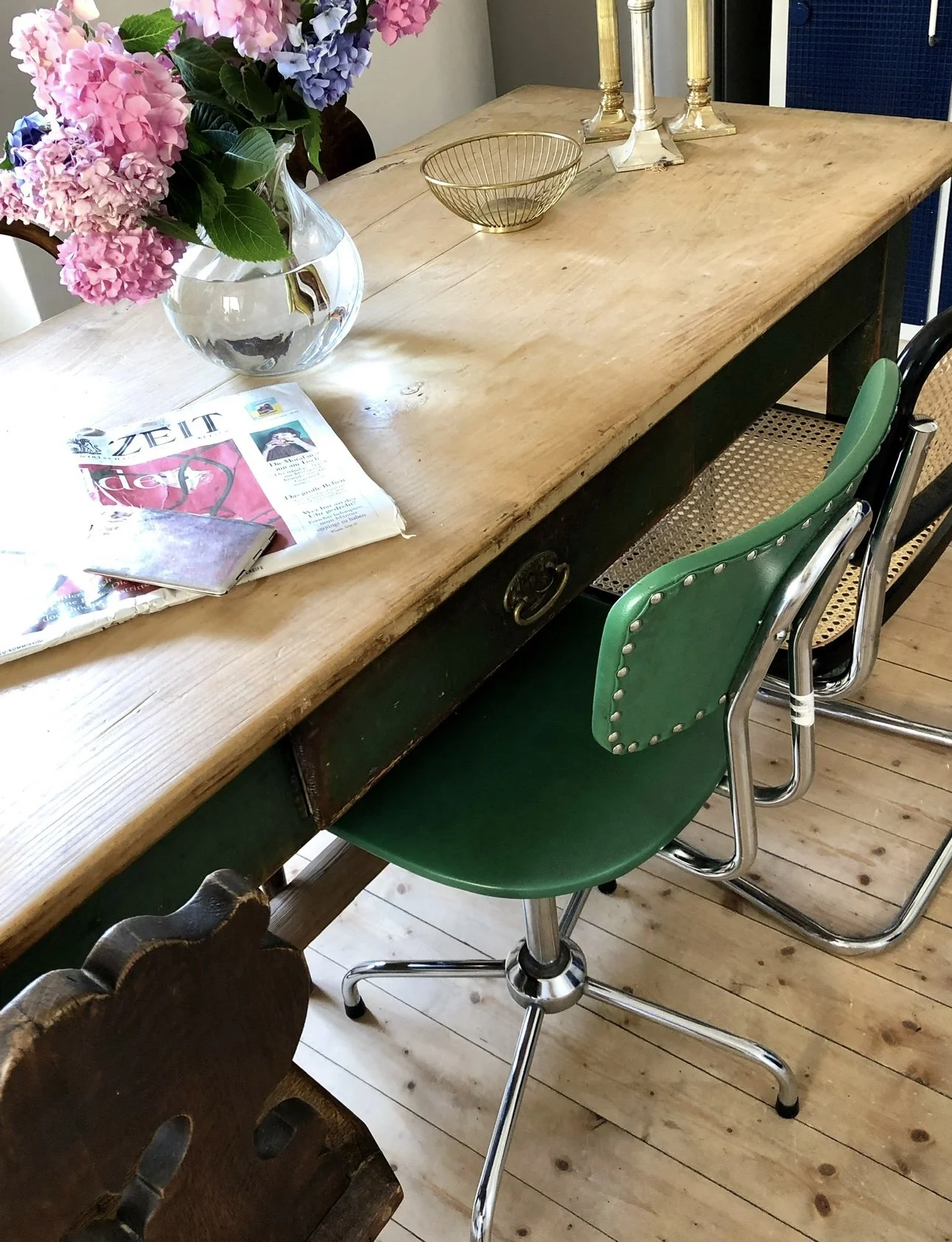 La grande table en bois, une chaise de bureau chinée et un bouquet