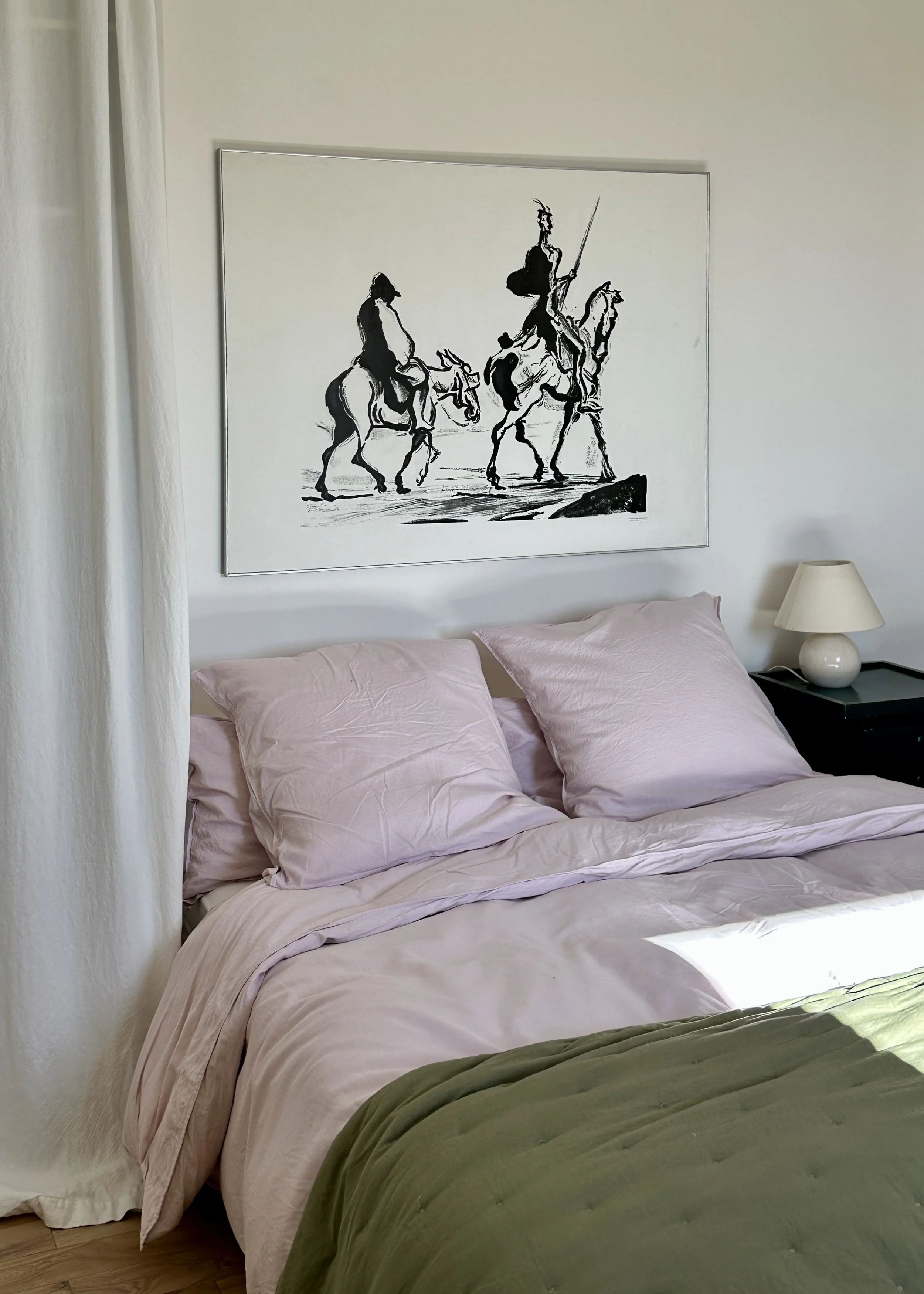 Chambre d'amis avec linge de lit lilas, plaid vert olive et grand dessin encadré