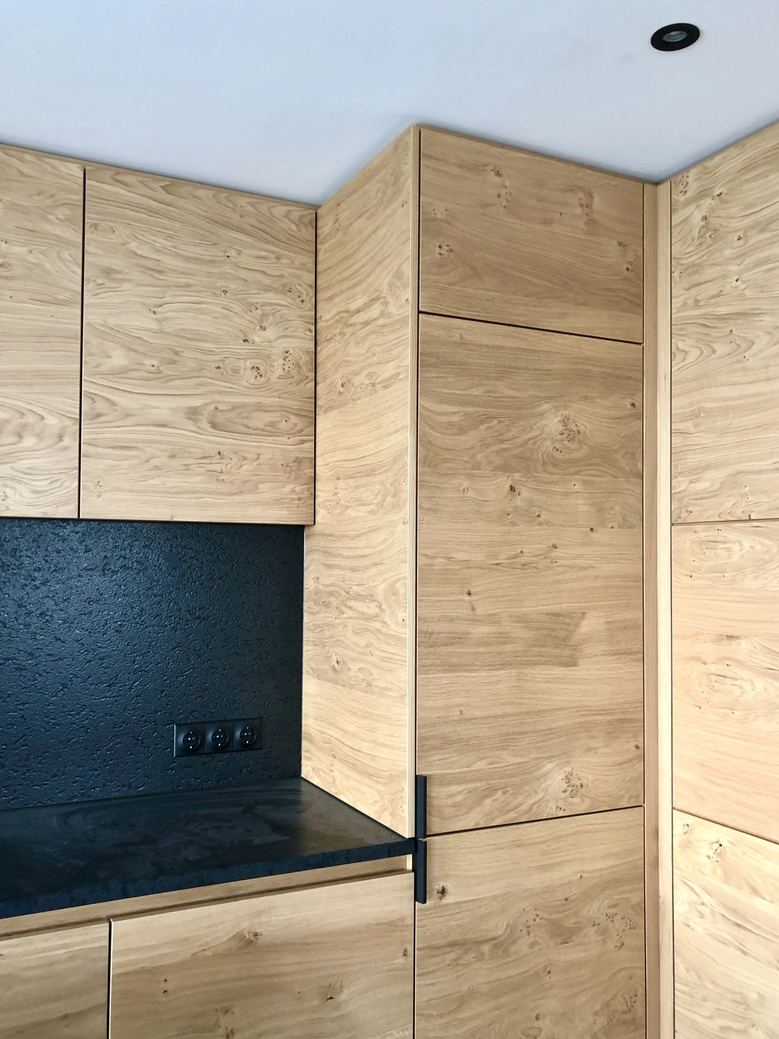 Cuisine sur mesure en chêne avec colonnes toute hauteur et crédence noire, menuiserie réalisée sur mesure