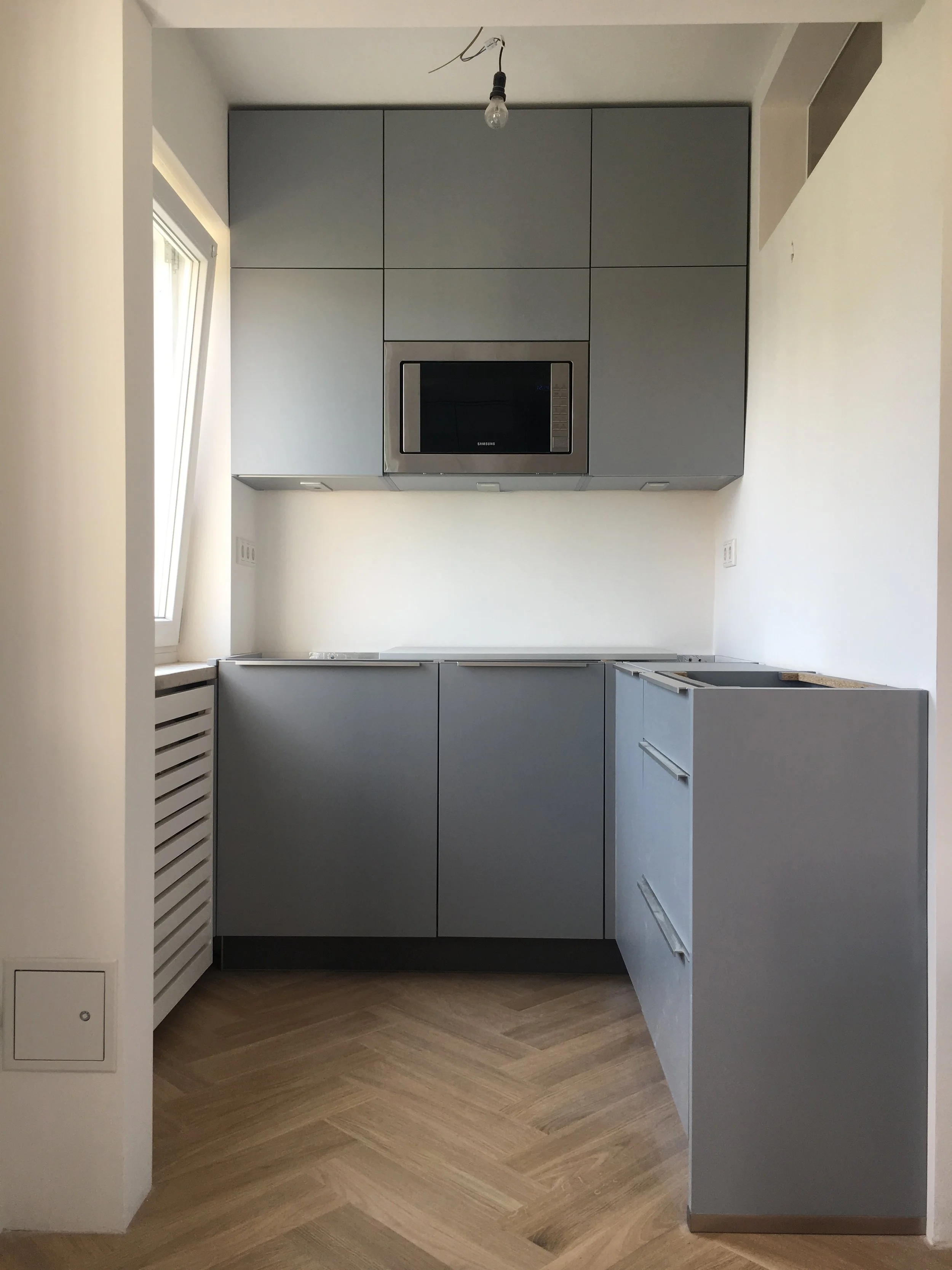 Chantier : pose de la cuisine sur mesure sur le parquet en chêne posé en chevrons