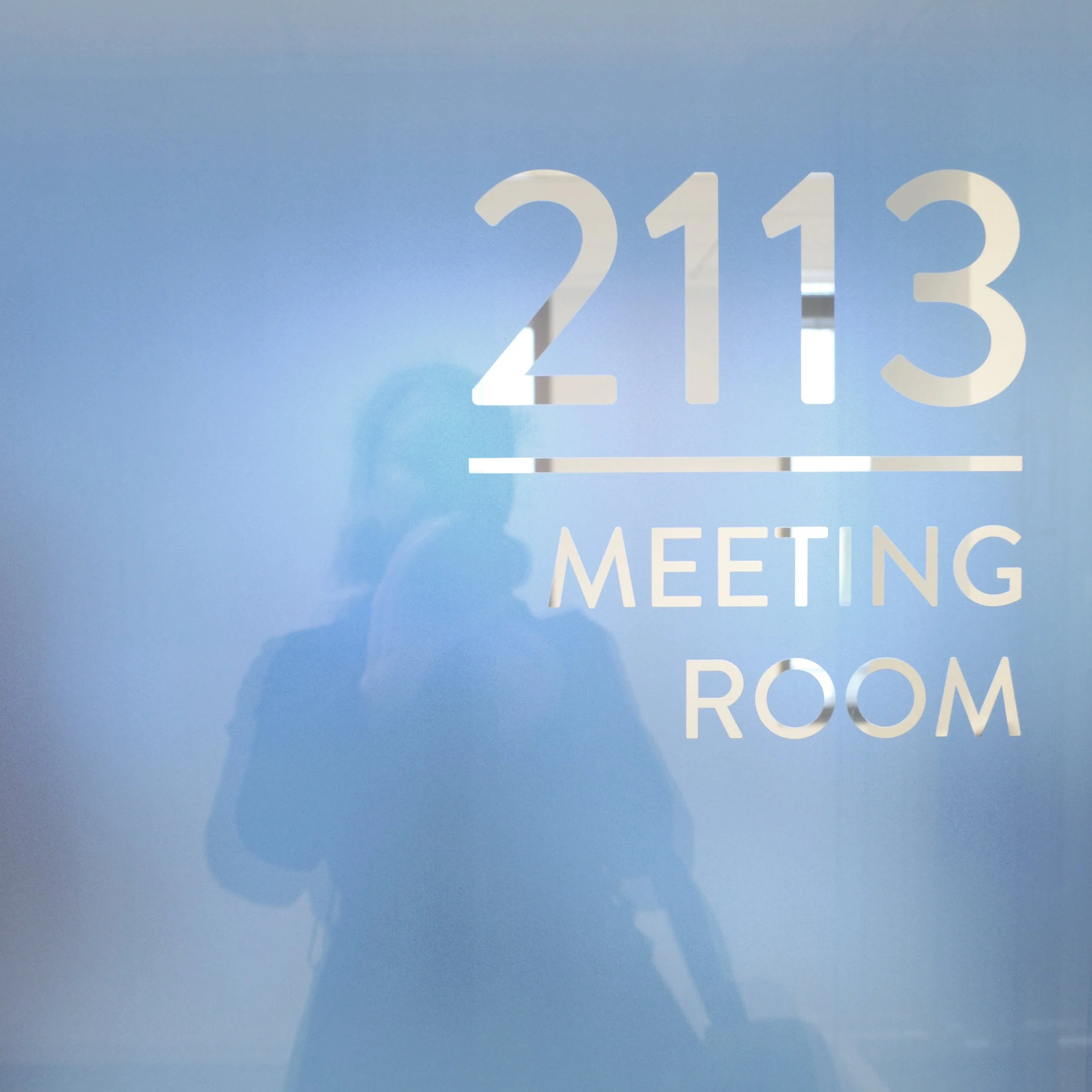 Signalétique « 2113 Meeting Room » en vitrophanie dégradée bleue sur cloison vitrée, siège OCDE Boulogne