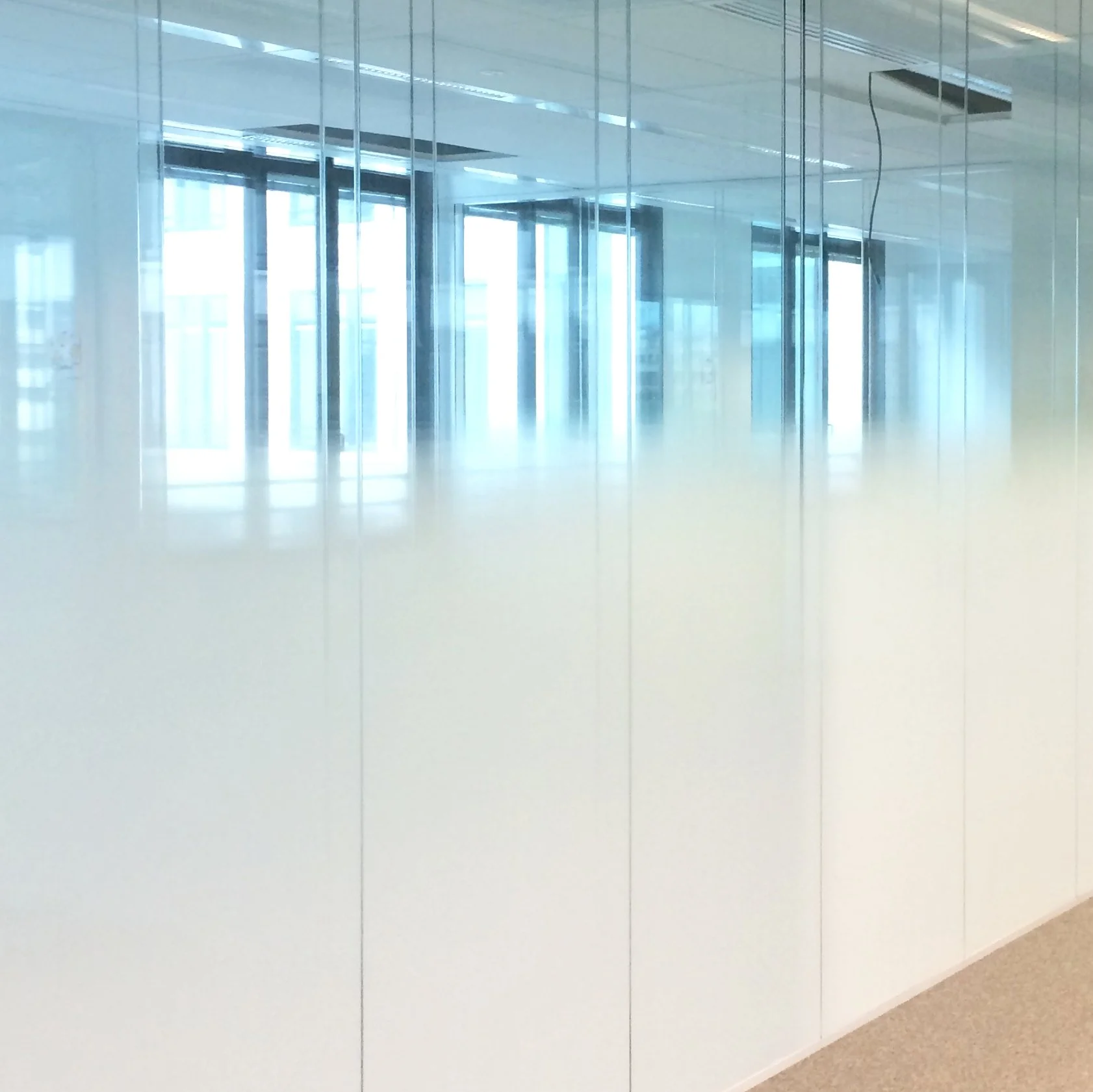 Couloir bordé de cloisons vitrées dépolies laissant filtrer la lumière, bureaux OCDE Boulogne
