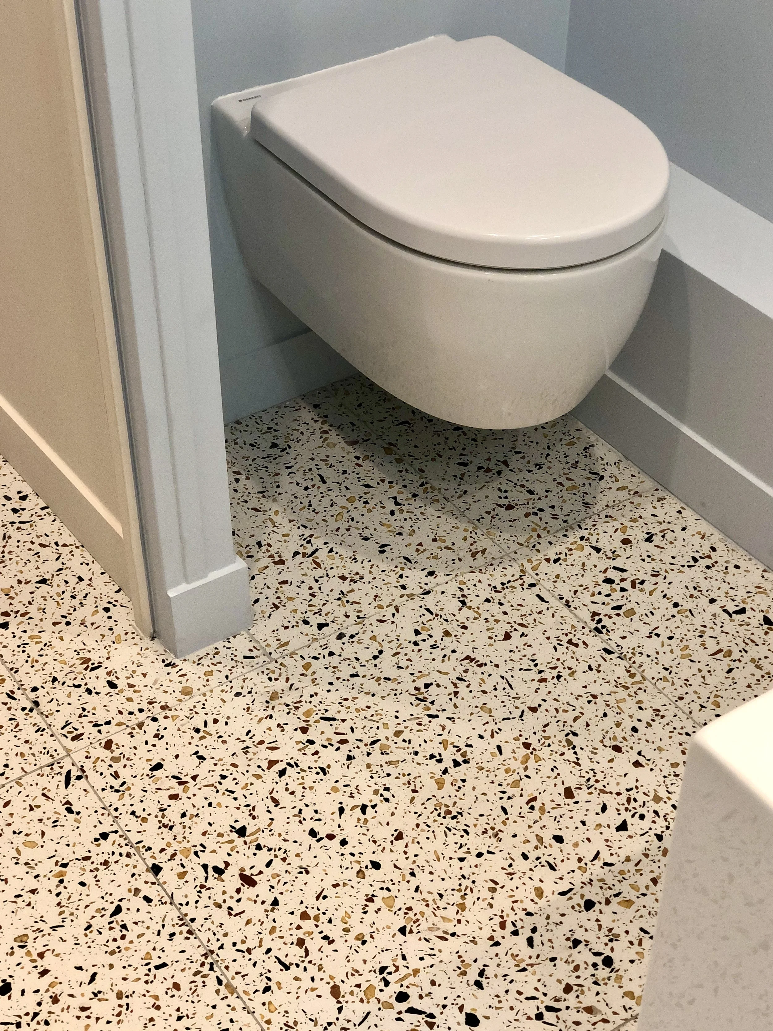 WC suspendu et sol en terrazzo à grands éclats dans la salle de bains