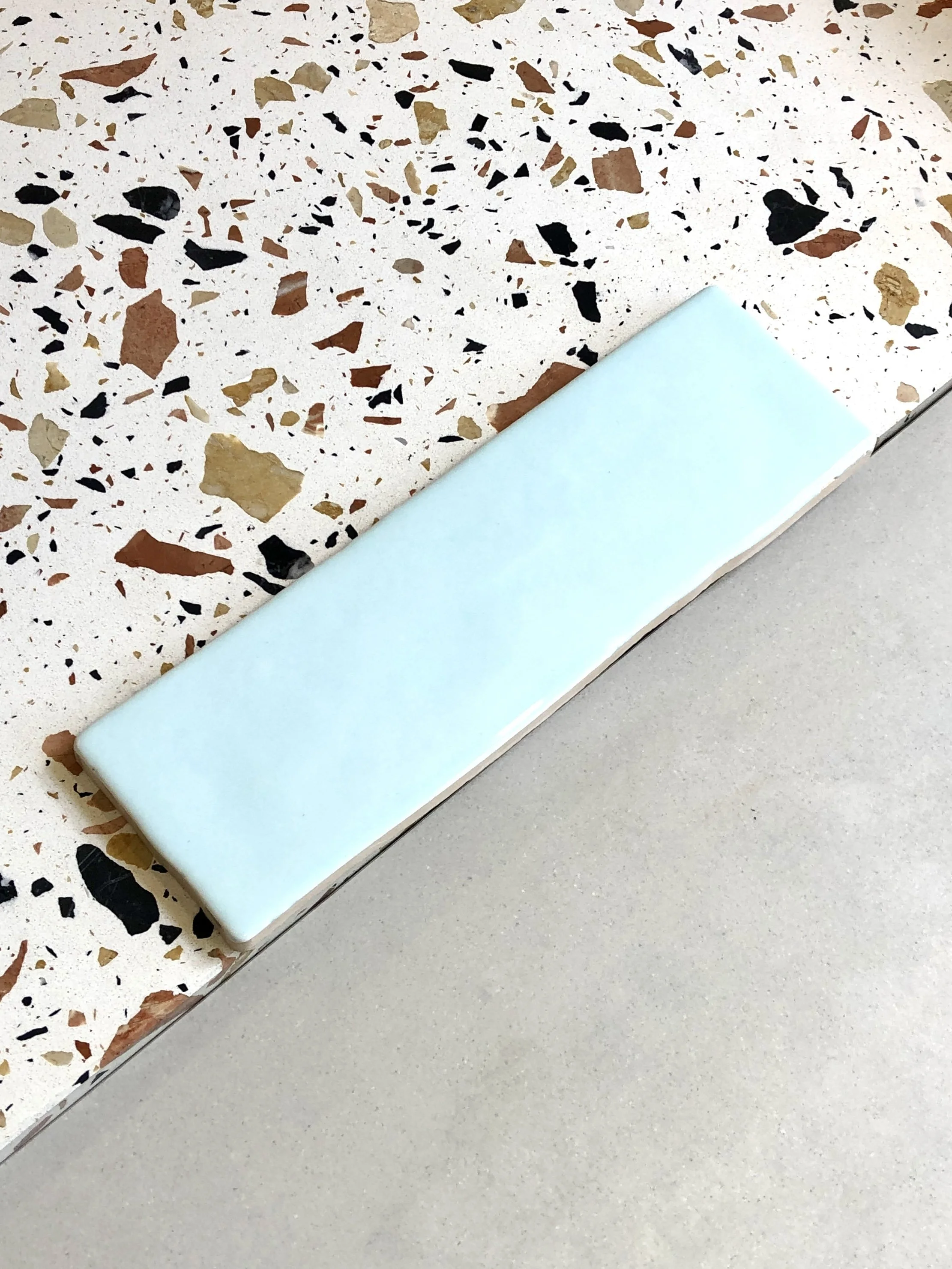 Échantillons de matériaux sur le chantier : terrazzo à grands éclats et carreau mural vert d'eau