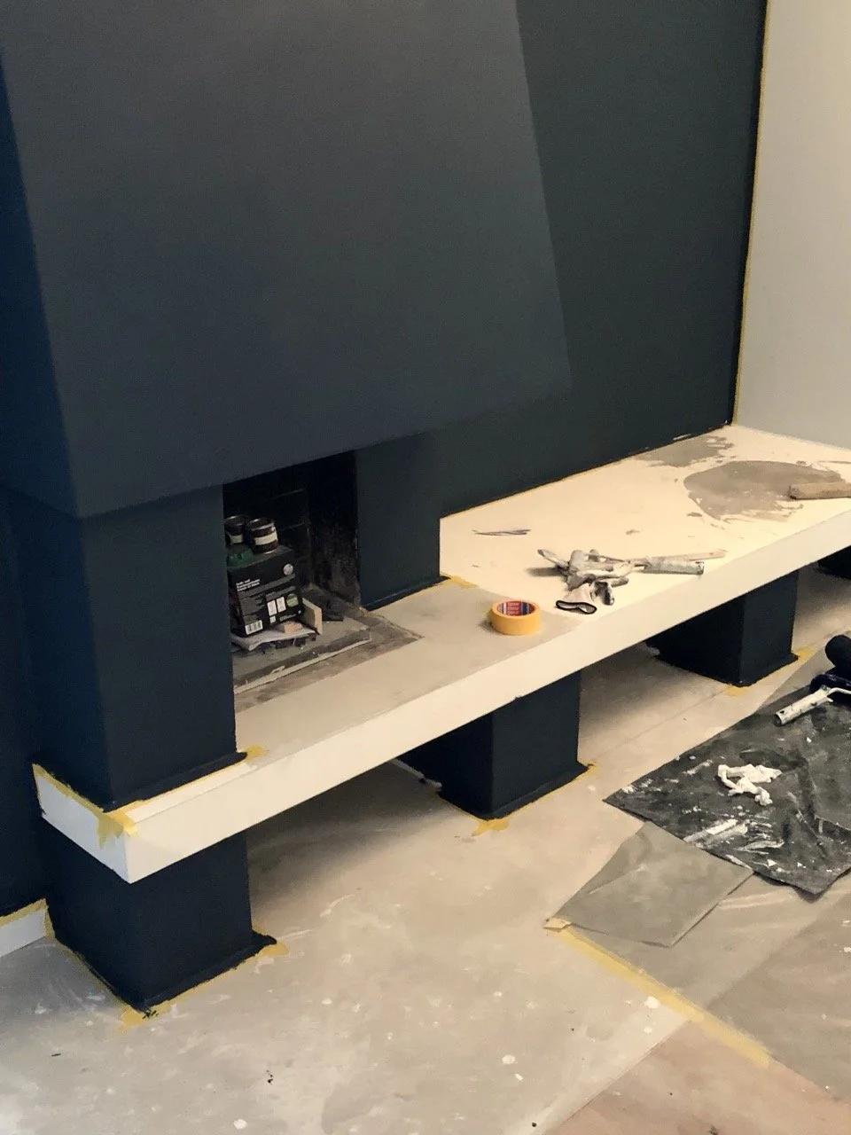 Chantier : la cheminée et son banc sur mesure en cours de finition, habillage bleu nuit