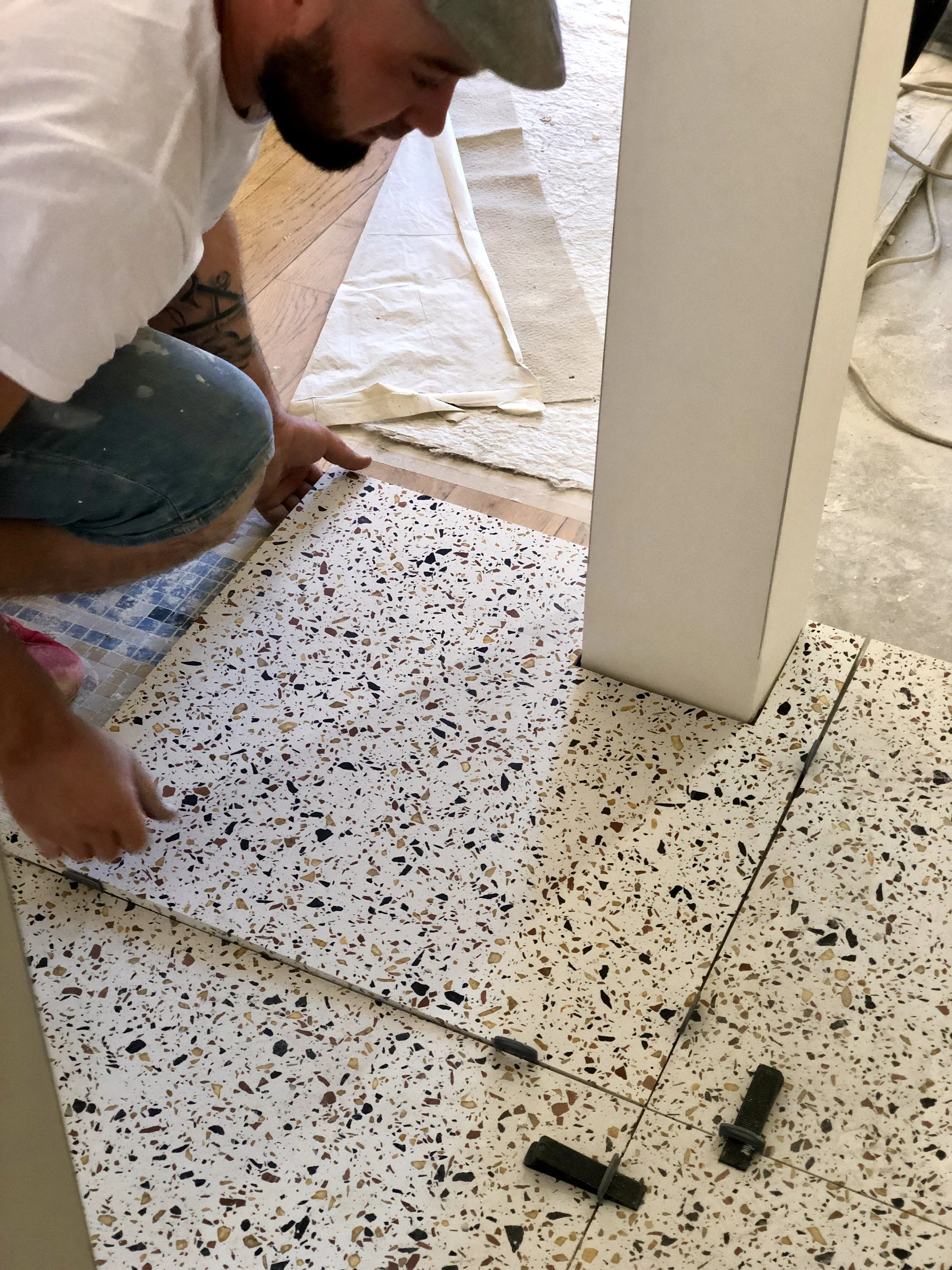 Chantier : pose du sol en terrazzo par le carreleur, dalle par dalle