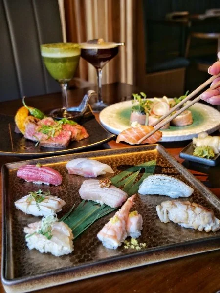 Assorted sashimi and sushi plates crafted cocktails.