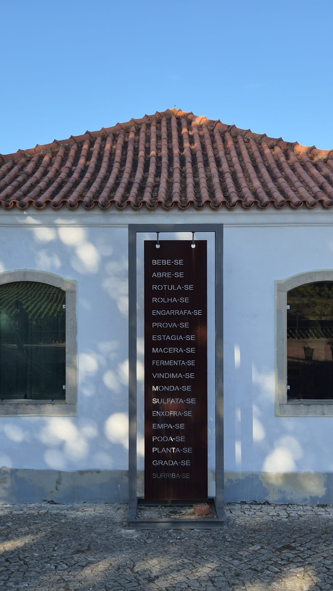 Placa decorativa em metal da Quinta do Monte D’Oiro onde se tem todas as etapas do vinho