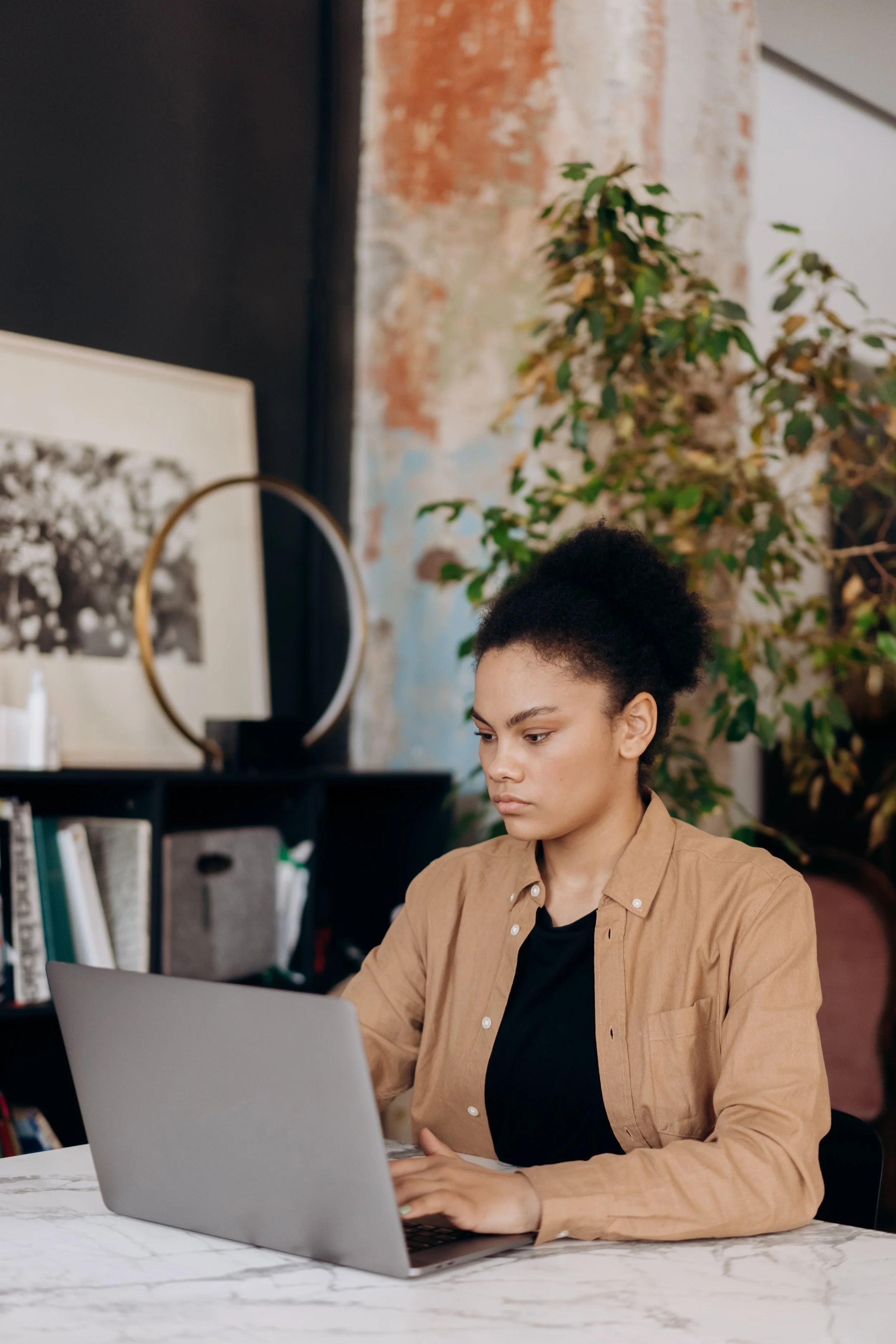 Survivor young Woman typing on a computer in her living room.