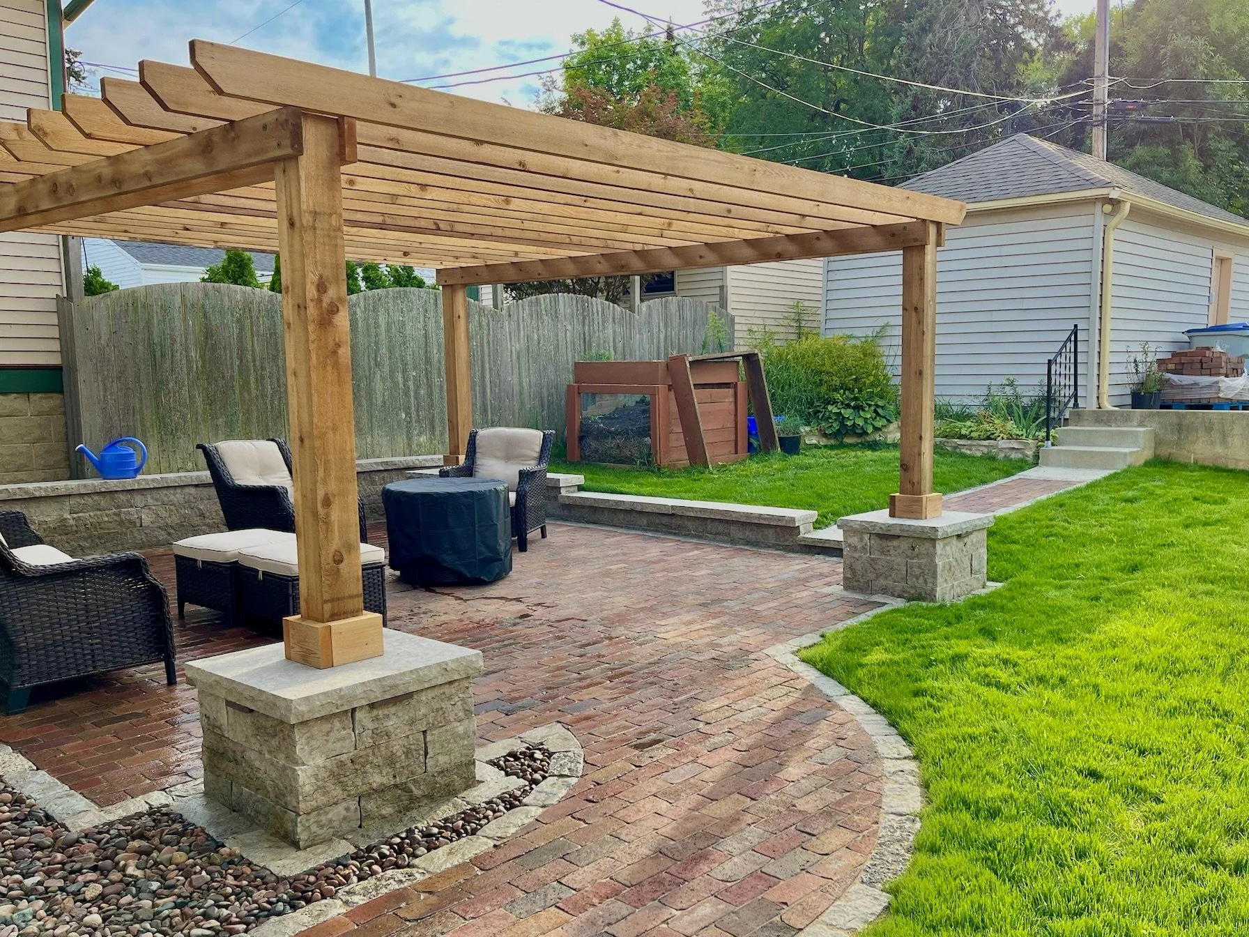 cedar pergola with stone pillars on antique brick patio