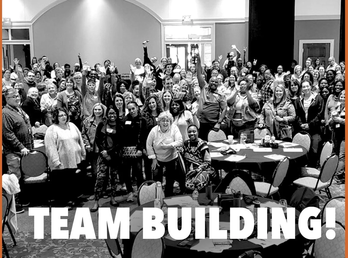 Large group of people posing in a room during a team building event.