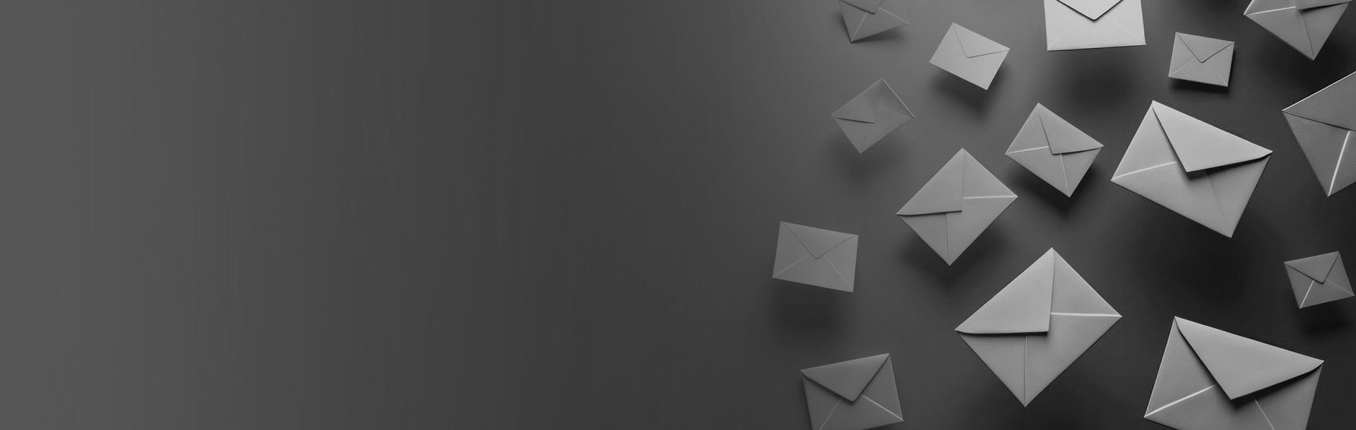 Multiple gray envelopes scattered on a dark gray background.