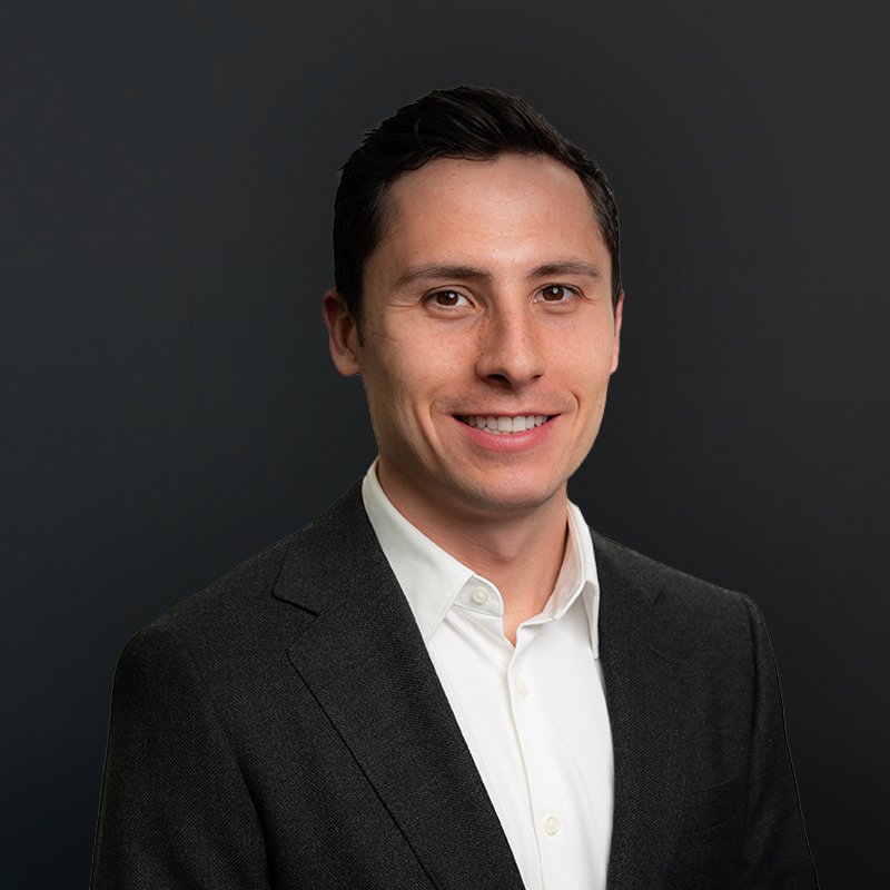 Smiling man in a business suit and white shirt, dark background