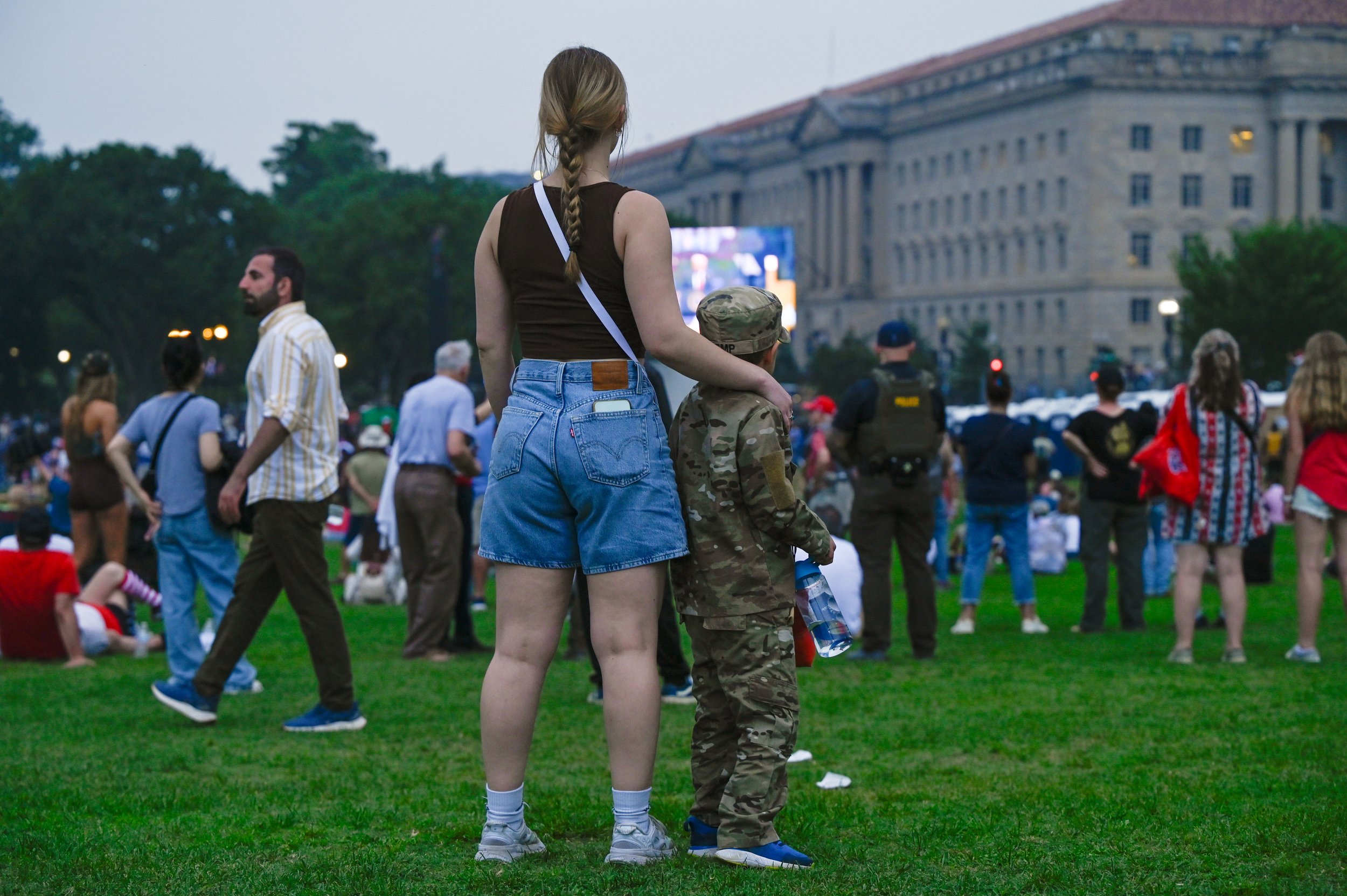 A woman stands with a young boy as President Donald Trump addresses the crowd during the Army's 250th birthday celebration in Washington, D.C., on June 14, 2025.