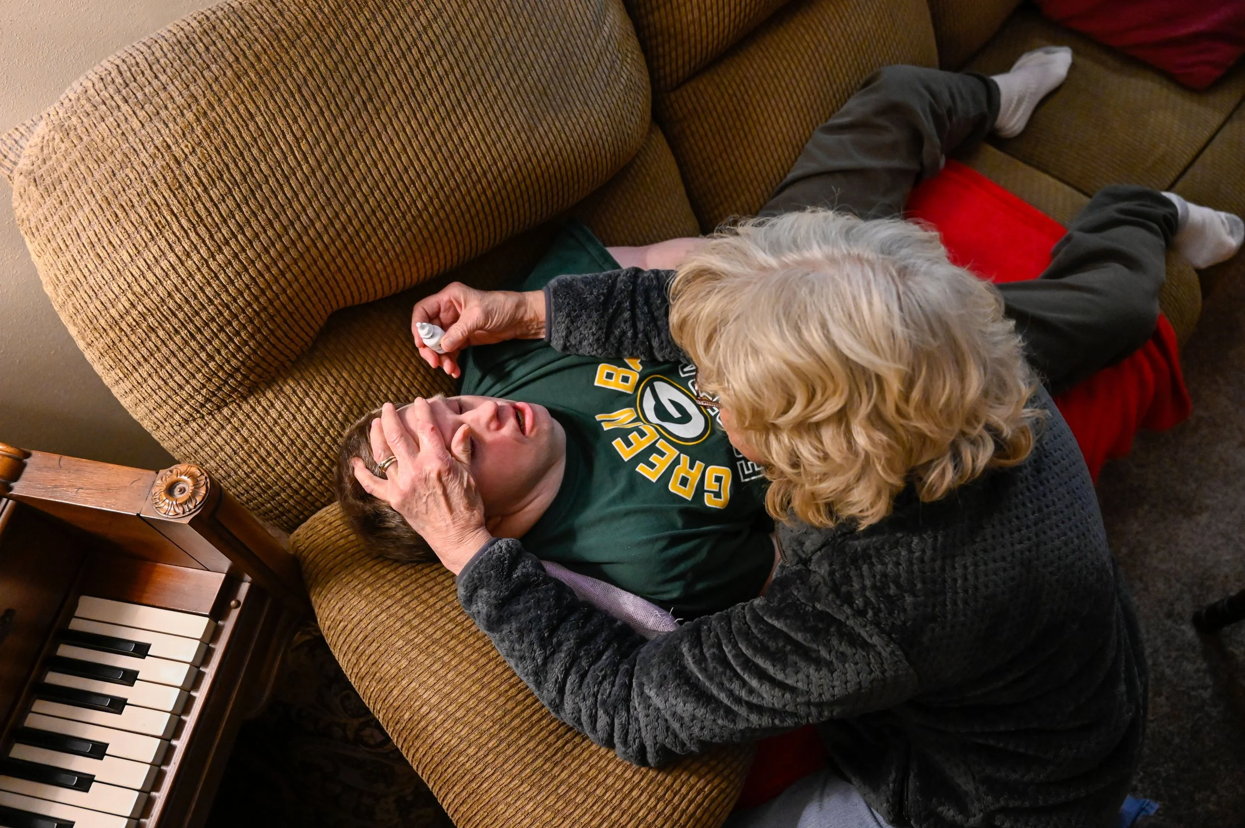 After a day of Thanksgiving festivities, Janet puts prescription eyedrops in Chad’s eyes. The eye drops need to be administered for three weeks, since Chad had surgery for glaucoma, which Janet also has. “He’s so good at taking the drops. He will hav