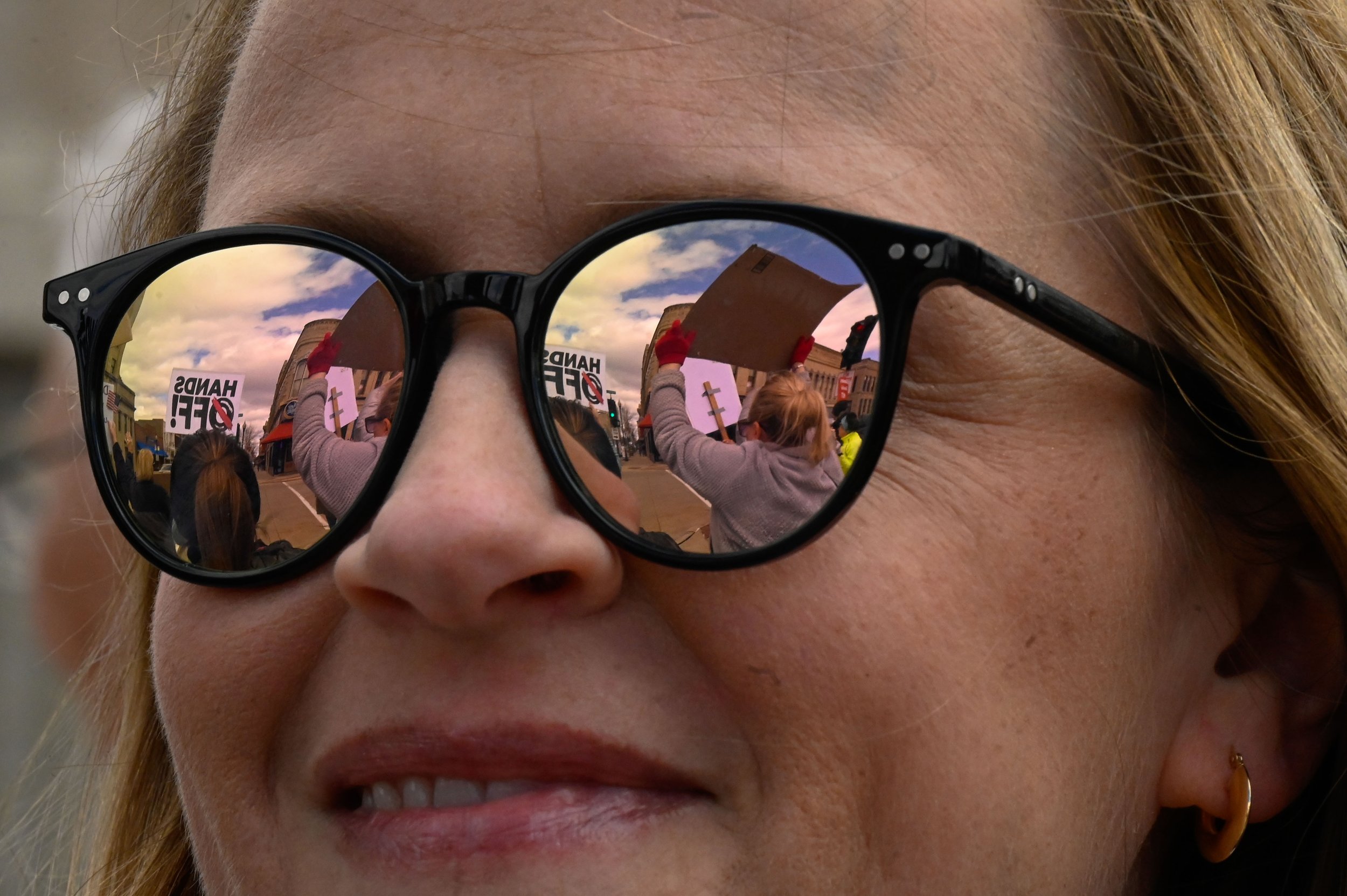 A woman smiles as she speaks with another participant of the "Hands Off!" protest at at Opera House Square in Oshkosh, Wisconsin on April 5, 2025. The protest on Main Street began small but eventually drew a large crowd of protesters. (Photo by Advan