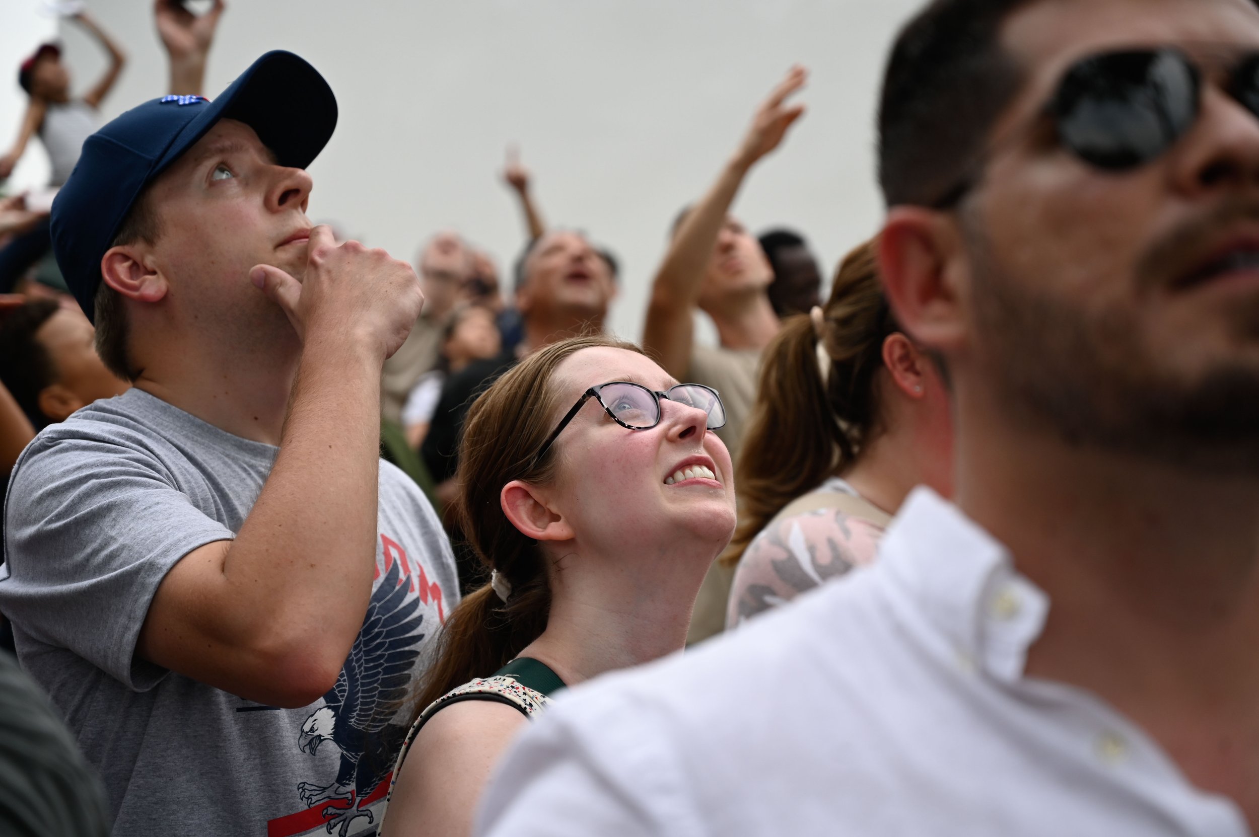 Attendees of the U.S. Army's 250th birthday celebration watch as U.S. Army Golden Knights float over the National Mall in Washington, D.C. on June 14, 2025.